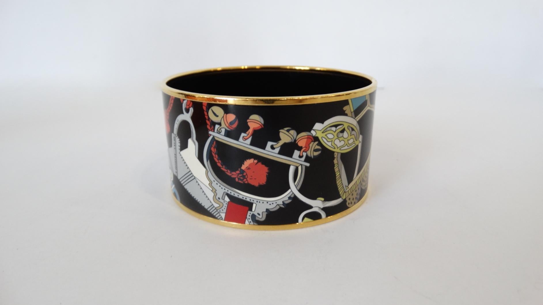 Accessorize Your Outfit With This Rare Hermes Paris Les Etriers Cuff! Contrasting against the black Enamel background is a detailed and beautifully colored Enamel motif of the signature Hermes Les Etriers (meaning stirrups) wrapping around the cuff.
