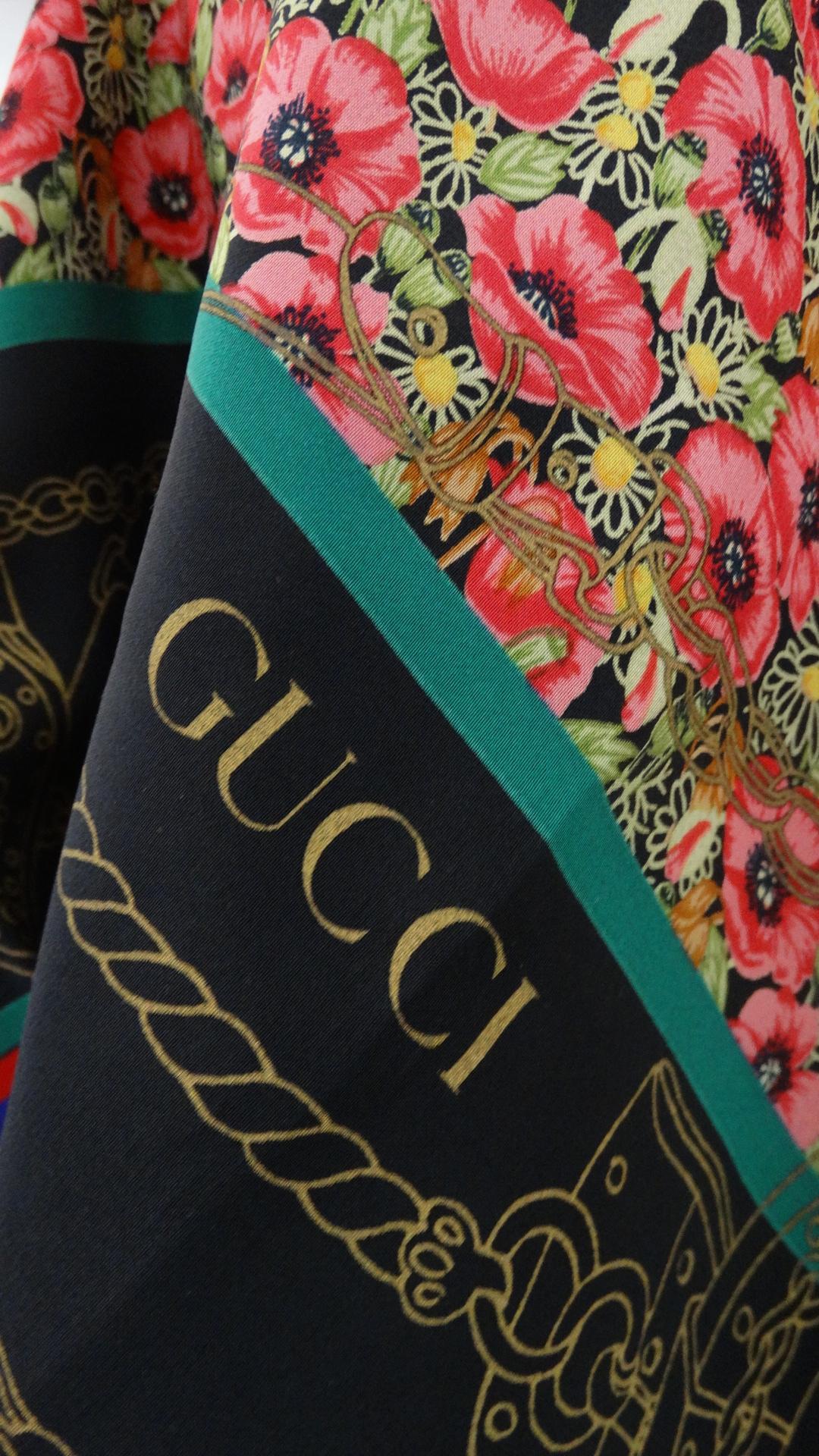 Amazing 1980s floral scarf from none other than Gucci! Solid black background with multicolored stripes around the perimeter, framing a dense, lush floral print! We love scarves for their versatility- wear knotted around the neck as an ascot, tie