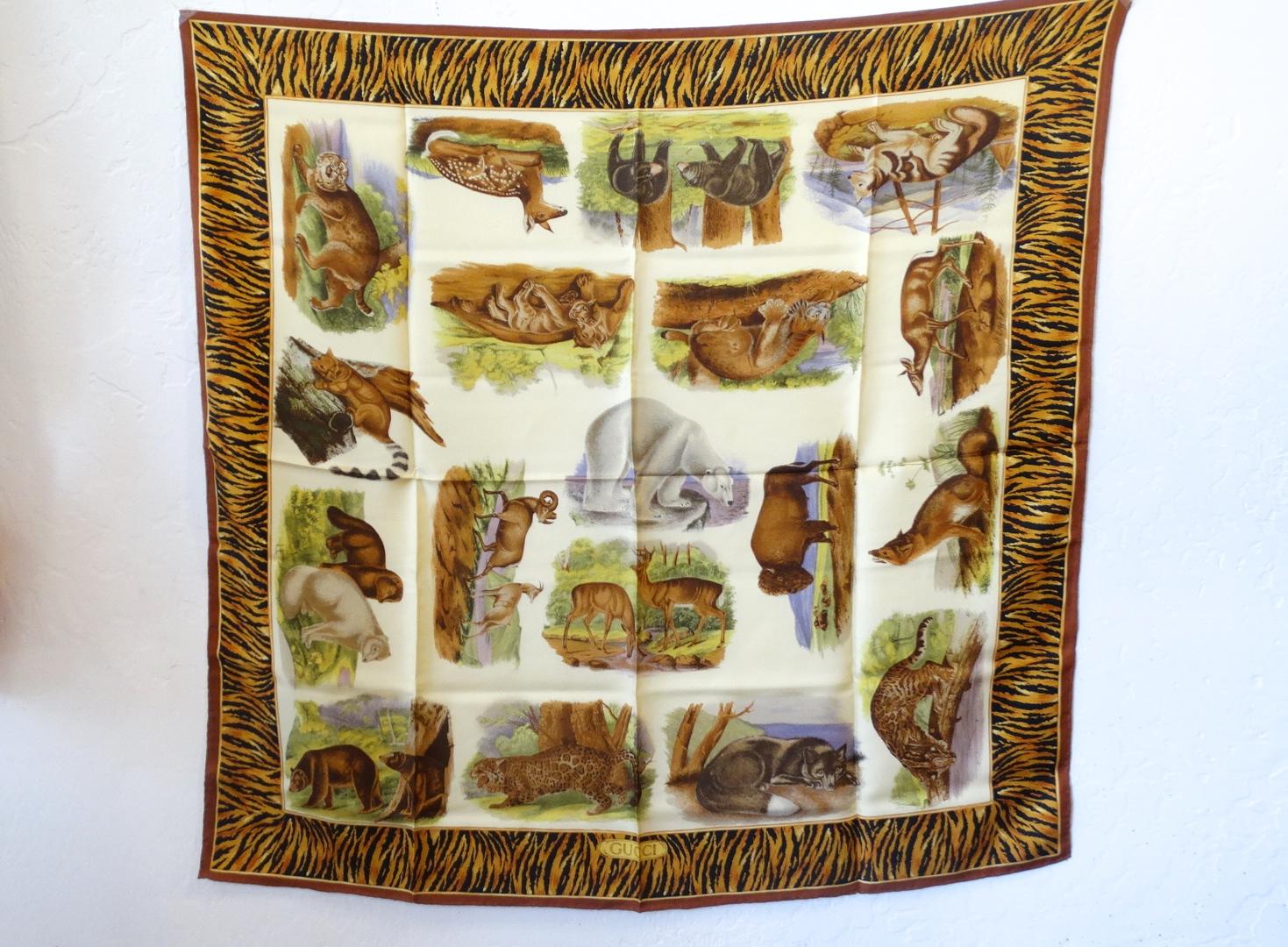 Unique 1980s Gucci Animal Kingdom printed silk scarf! Solid white background printed with an array of animals- from deers to polar bears to bison! Thick border of orange tiger stripes around the perimeter. Signed GUCCI in the bottom corner. The size