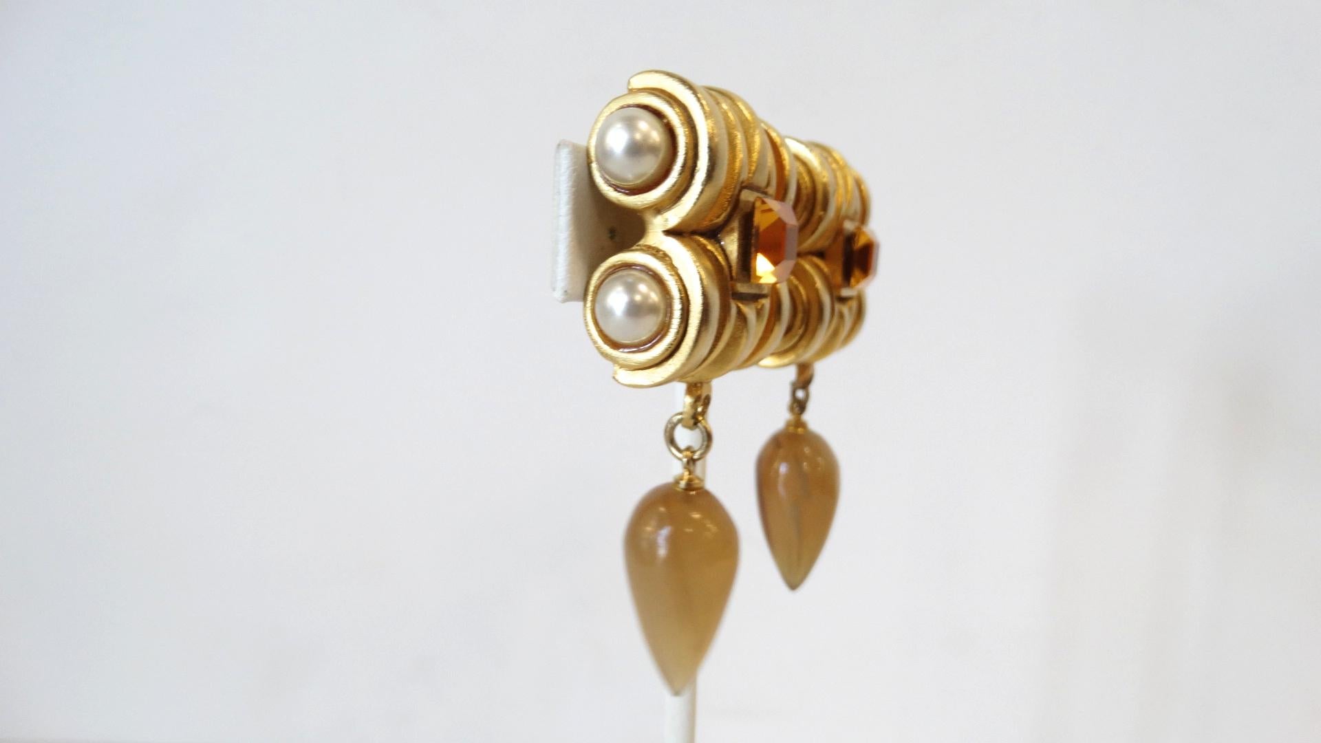 Your Perfect Earrings For Fall Have Arrived! A gold plated top resembling an Ionic Greek column features four pearls and an Amber rhinestone in the center. Hanging off the structured clip on closure top is a tear drop Amber Crystal. Unsigned.