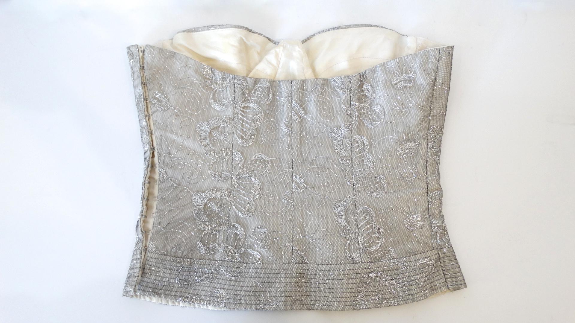 The resurgence of the Corset trend is in full force! Rock a one of a kind piece of your own with this futuristic Christian Dior Boutique silver bustier! Incredible boned construction with shaped, lined cups. Glittering silver brocade like fabric