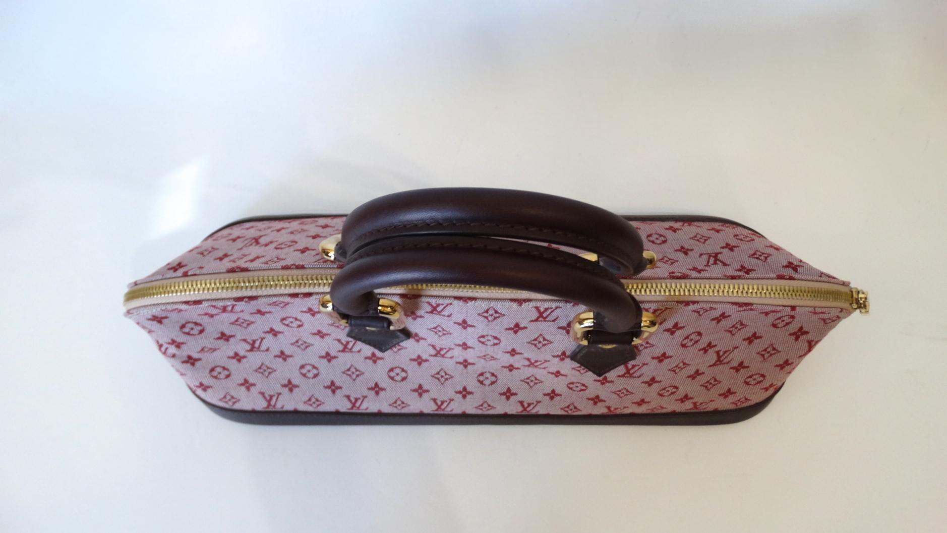 Mini LV is so en vogue! Rock a piece not everyone can get their hands on with our adorable elongated mini Alma from none other than Louis Vuitton! Crafted from a quality canvas material, printed with red and pink monogram LV pattern all over. Deep