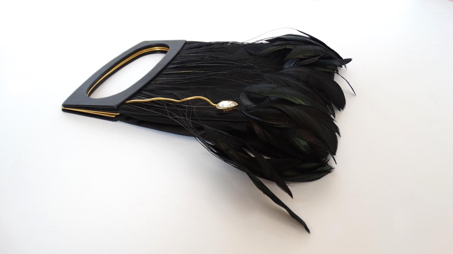 The Most Gorgeous and Elegant Evening Bag Is Waiting For You! Designed by Lalique, the ultimate French luxury designer, this black silk evening bag features gold-tone hardware and flat leather magnetic handles. The front face of the bag is decorated