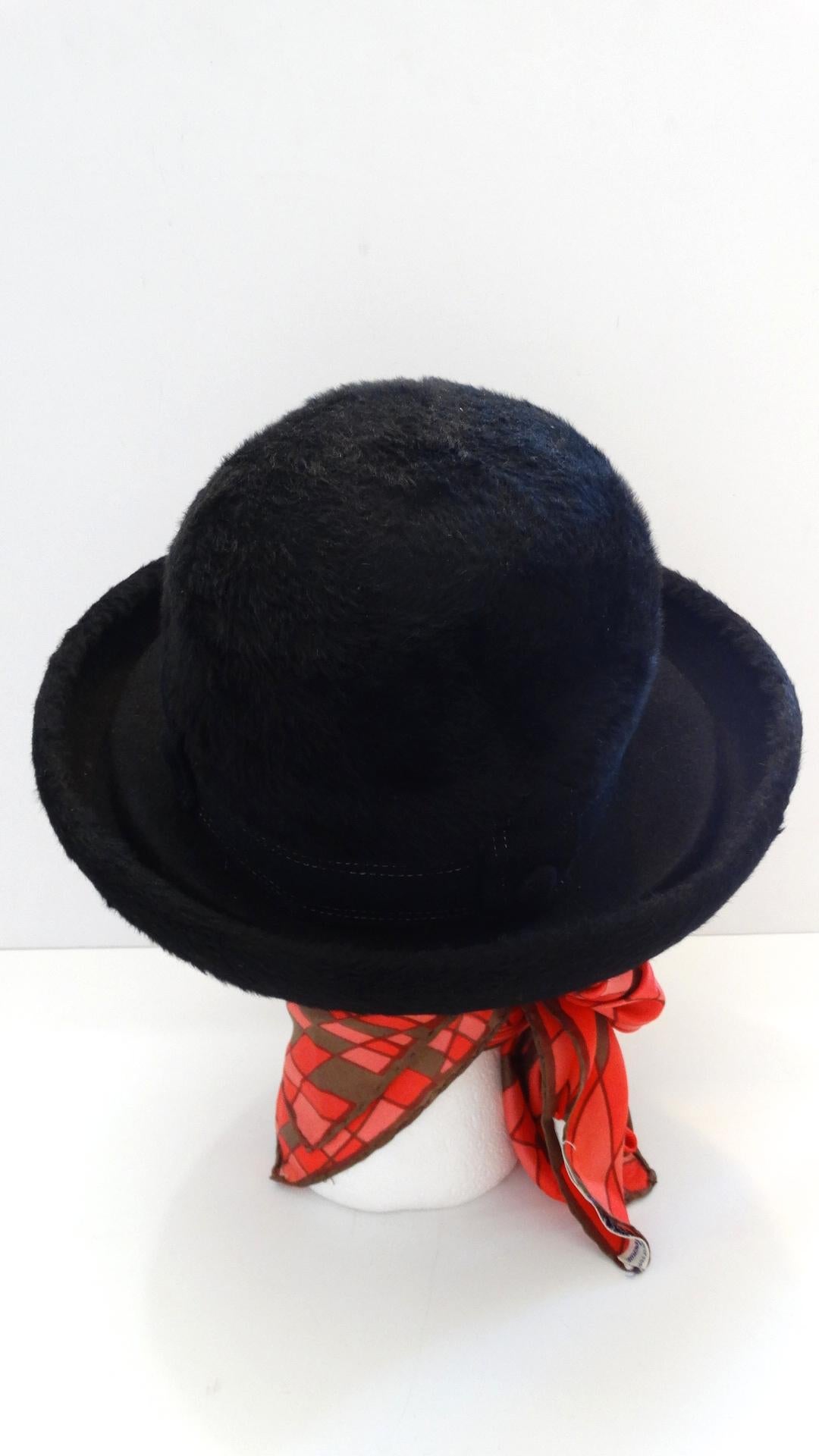 The Perfect Winter Hat Has Arrived! Circa 1960s, this Dior derby style hat features a porkpie brim. The crown of the hat and the outer trim of the brim  are made of black faux fur. The inner brim is black wool felt. The crown features a band with