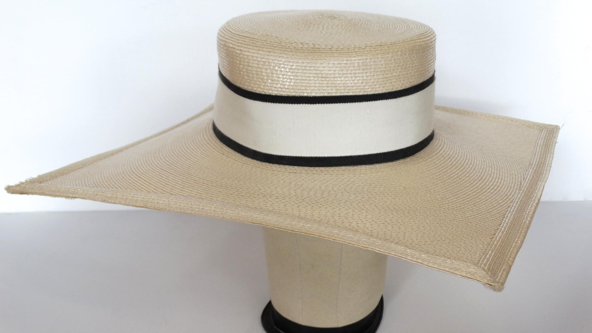 Say Hello To The Most Amazing YSL Hat! Circa early 1970s, this hat is a classic boater with a unique square shape brim. Features a large white ribbon with black trim around the crown. Two removable fascinators are included on the interior trim for a