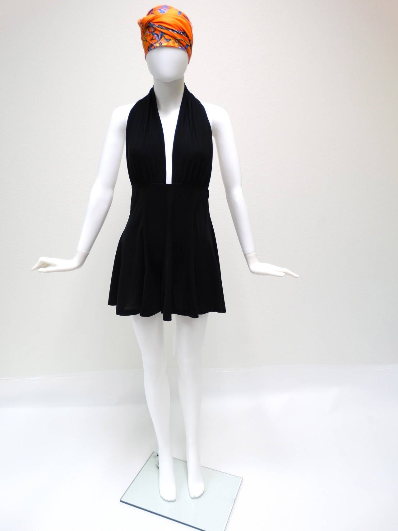 Have a Marilyn moment with this fabulous Norma Kamali halterneck mini dress with attached under bodysuit circa 1980s. Plunging V-neck, backless mini, slips on in jet black. Fabric is Spandex and Lycra marked sz large…Fits a modern sz 6 or 8