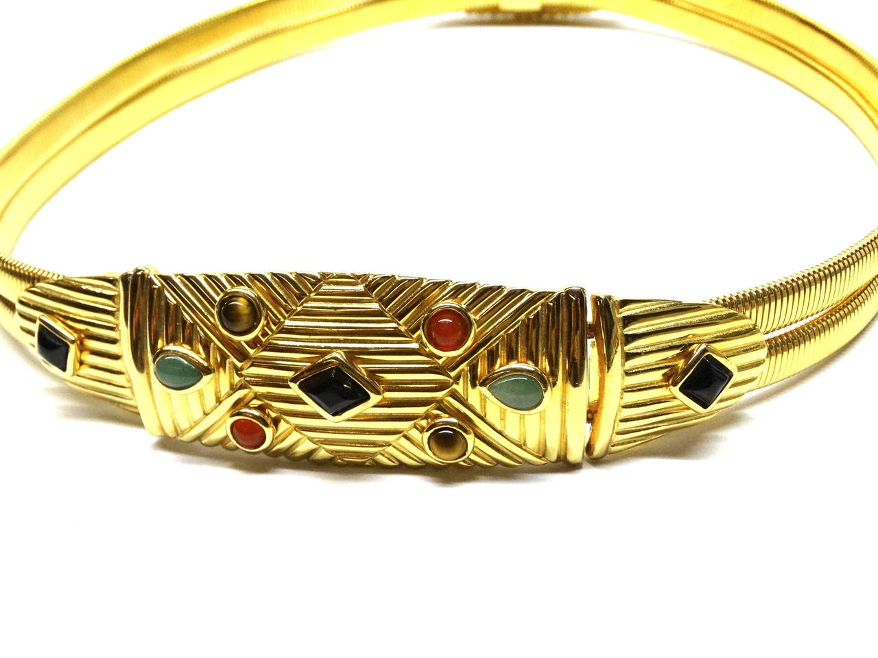 Judith Leiber gold gilt cord belt has semiprecious cabochon stones dating to the 1970's. This belt has Jade, Onyx, Tigers Eye on the front buckle plate with a  hook closure. On the back plate it has onyx cabochons Signed Judith Leiber… Fits a 25-26