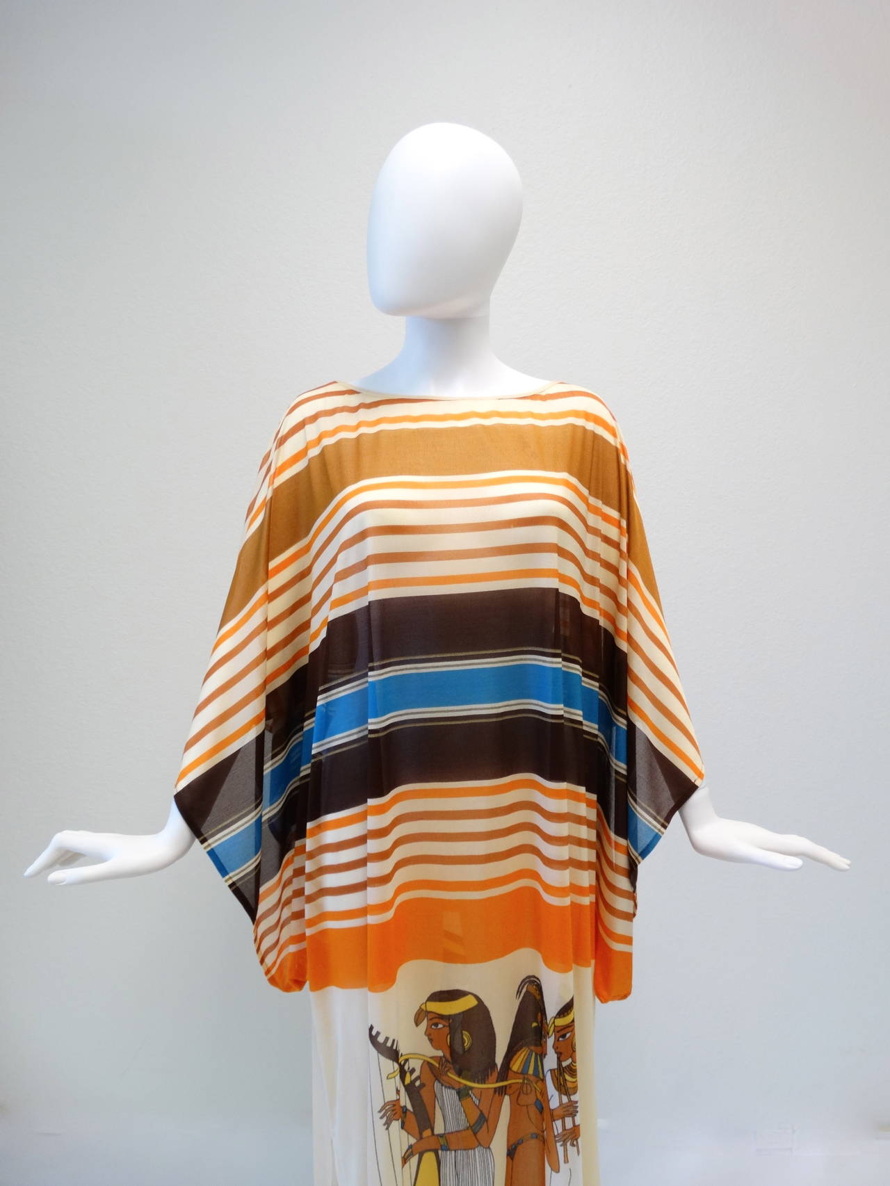 A beautiful vintage Gottex Kaftan Dress with an egyptian revival print on the front and back. Vibrantly printed in nudes, blue and brown. Sheer Kaftan slips over head with wide squared sleeves and side slits. Made in Israel 
Marked size