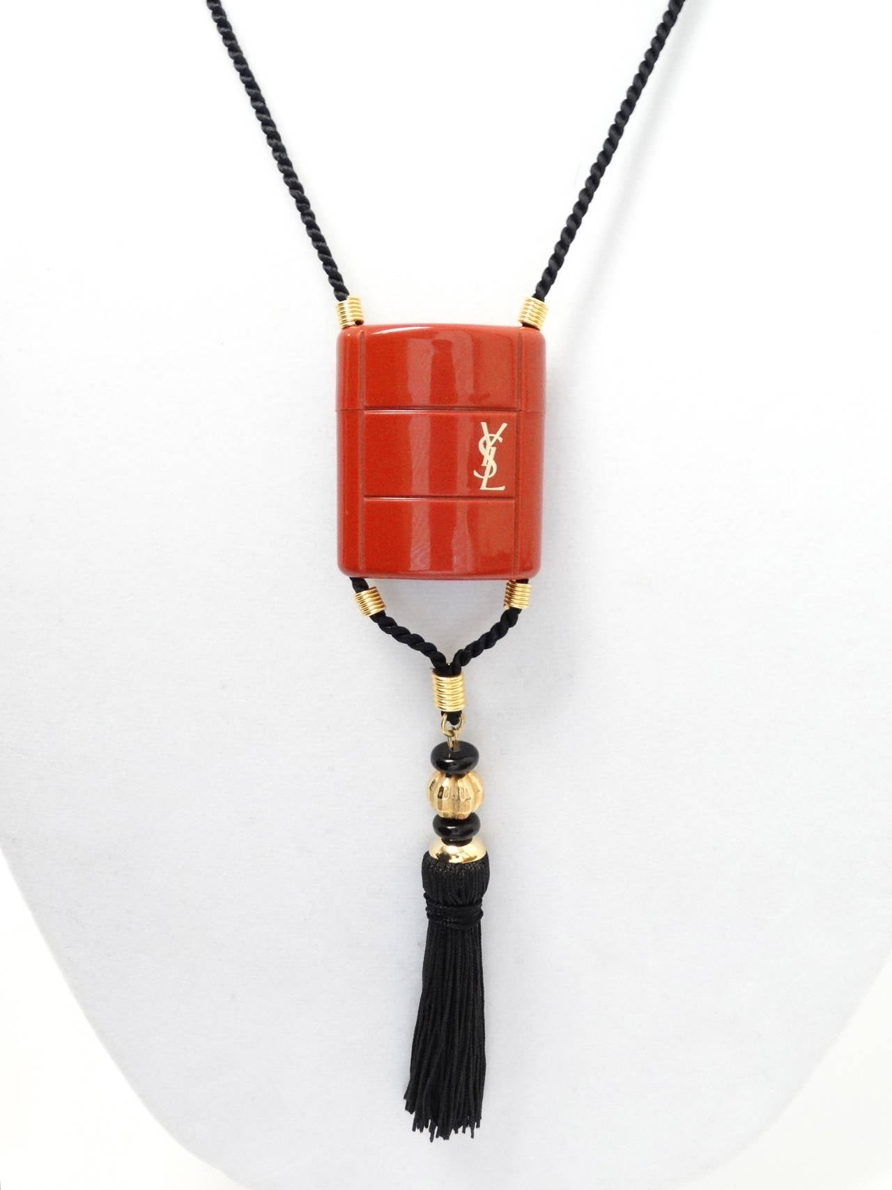 This Vintage YSL Opium Tassel Necklace is beautiful and collectable. Opium perfume was first released in 1977 and since the mid 80's these necklaces have been discontinued. This isn't just YSl it's a statement piece! A deep burnt  orange pendant