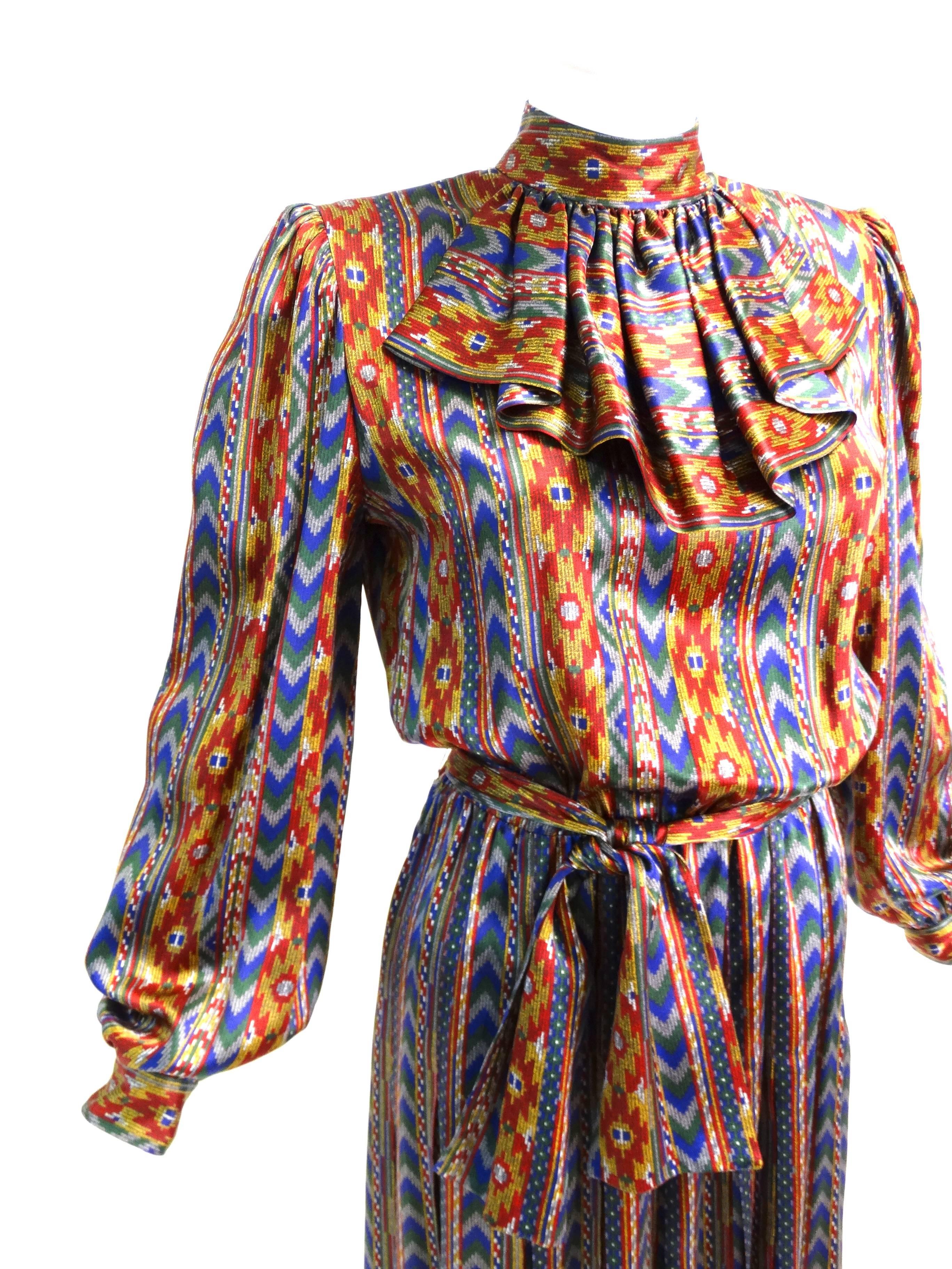 A fabulous dress by Givenchy for Nouvelle Boutique in Paris circa 1980's! A classic cut in silk with the most amazing aztec/southwest print. This piece has a high neck with a  victorian ruffled collar, so Givenchy! A true drop pleat on the pleated