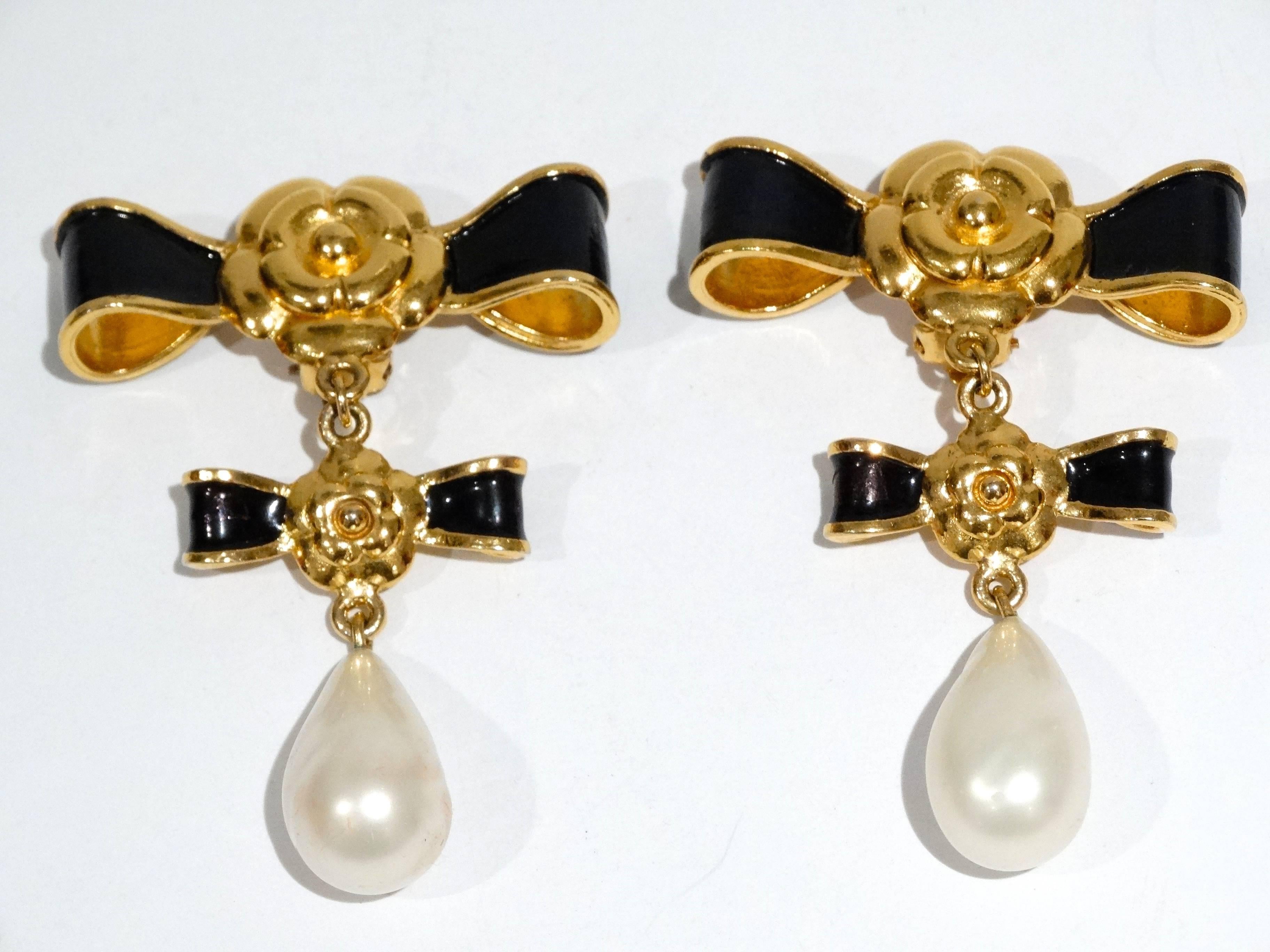 Looking for a dramatic earring? here are a rare early pair of 1990's Chanel double bow earrings with black enamel and gold plate. Each bow has the iconic camellia centers and large pearl drops! The back of the earrings has some wear but the