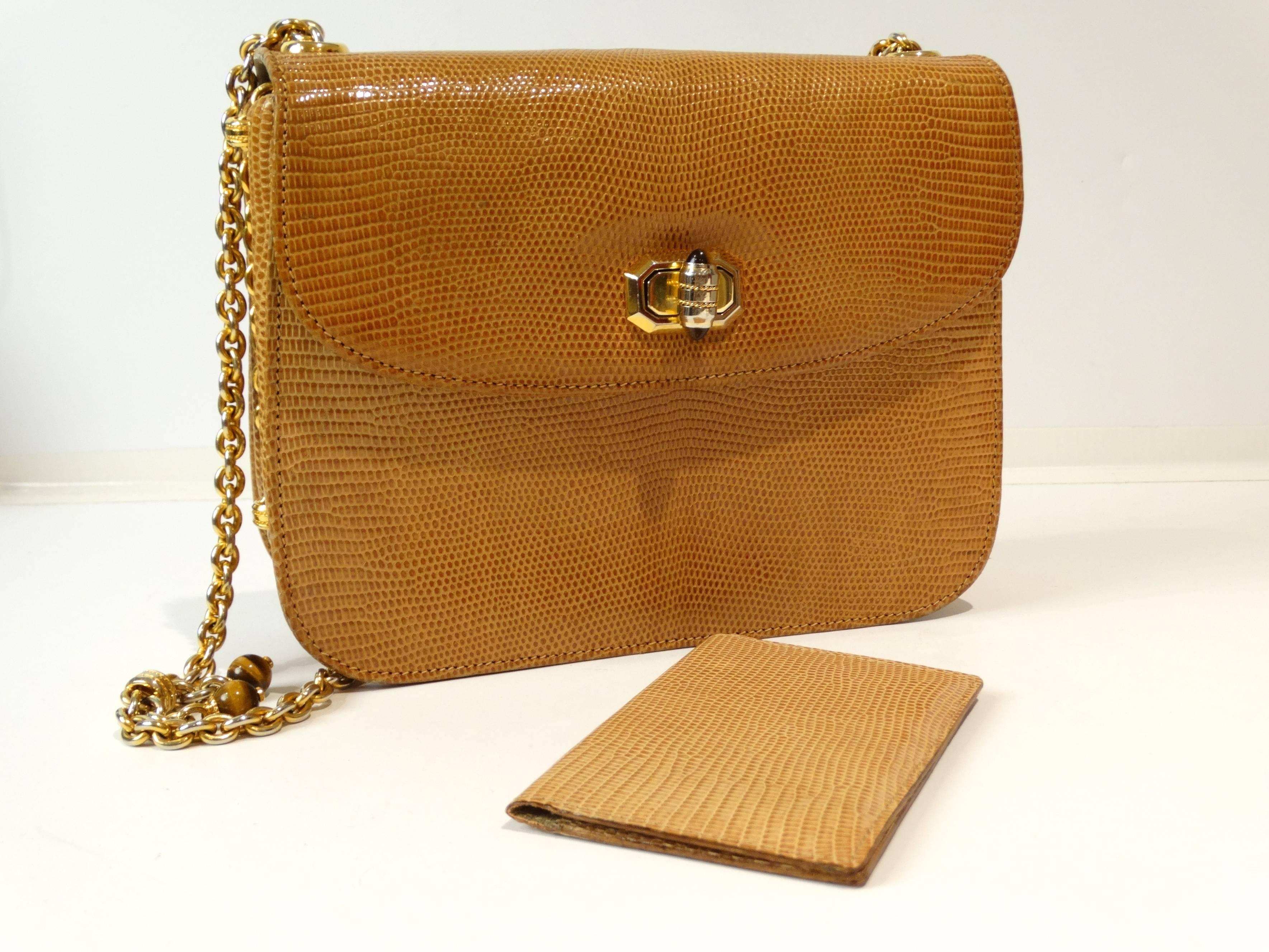 A rare and timeless vintage 1972 Gucci shoulder bag in a tan lizard skin. This handbag has a gold chain with two polished tigers eye stones hanging off the right side of the chain. The handbag has a gold turn closure with pieces of polished tigers