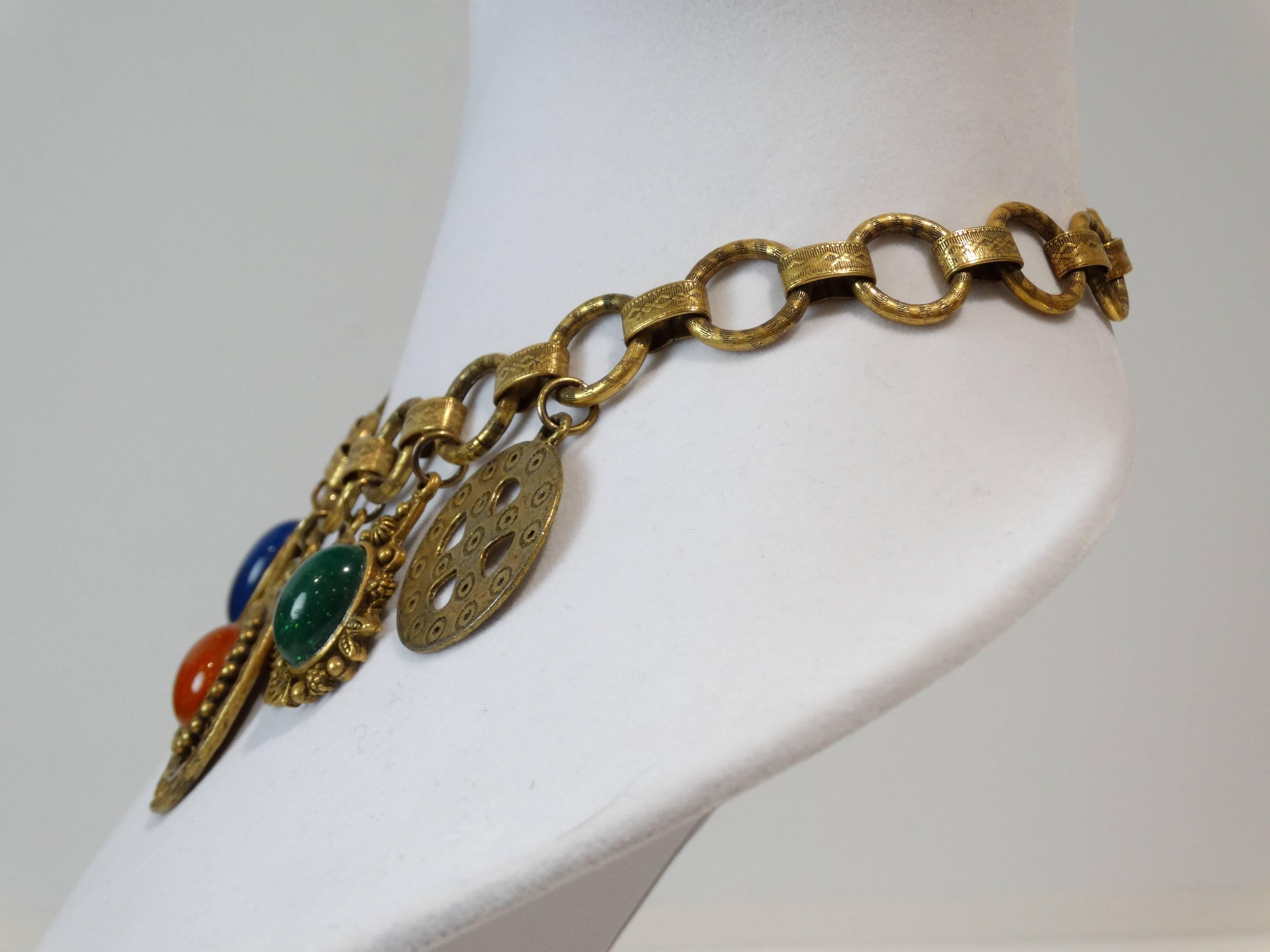 1989 Les Bernard ethnic charm necklace( reminds me of Morocco). Gilt metal links with designs, item features various 'charms' some mounted with art glass cabochons. Signed Les Bernard Inc with fold over closure clasp.

Measures 
17