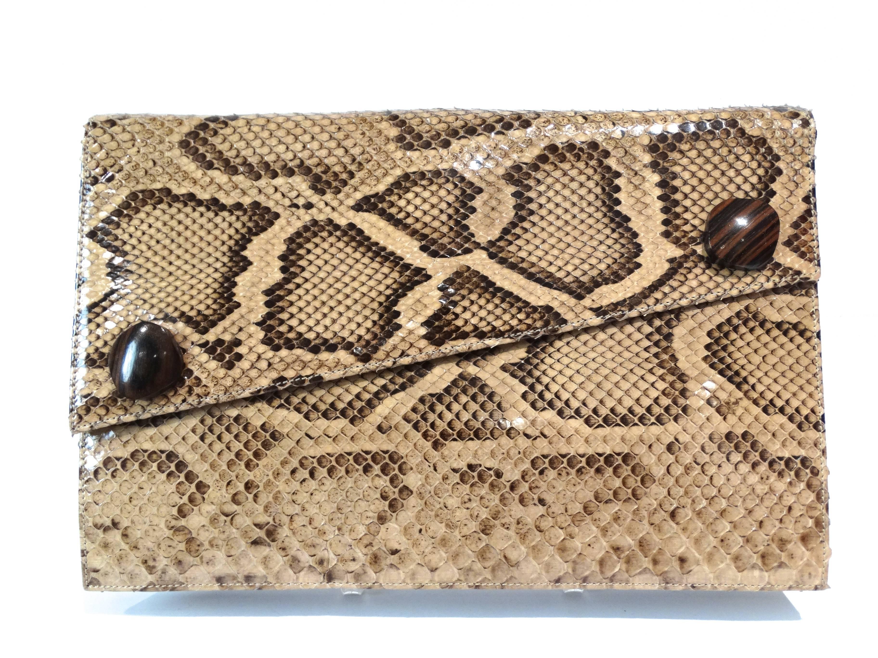 Saint Laurent Rive Gauche brown and beige python large clutch bag. It fastens at front with snap button and it is enriched by two wood sculpture pieces on the front envolpe. Clutch does have an attached woven strap on the inside. Perfect for day or