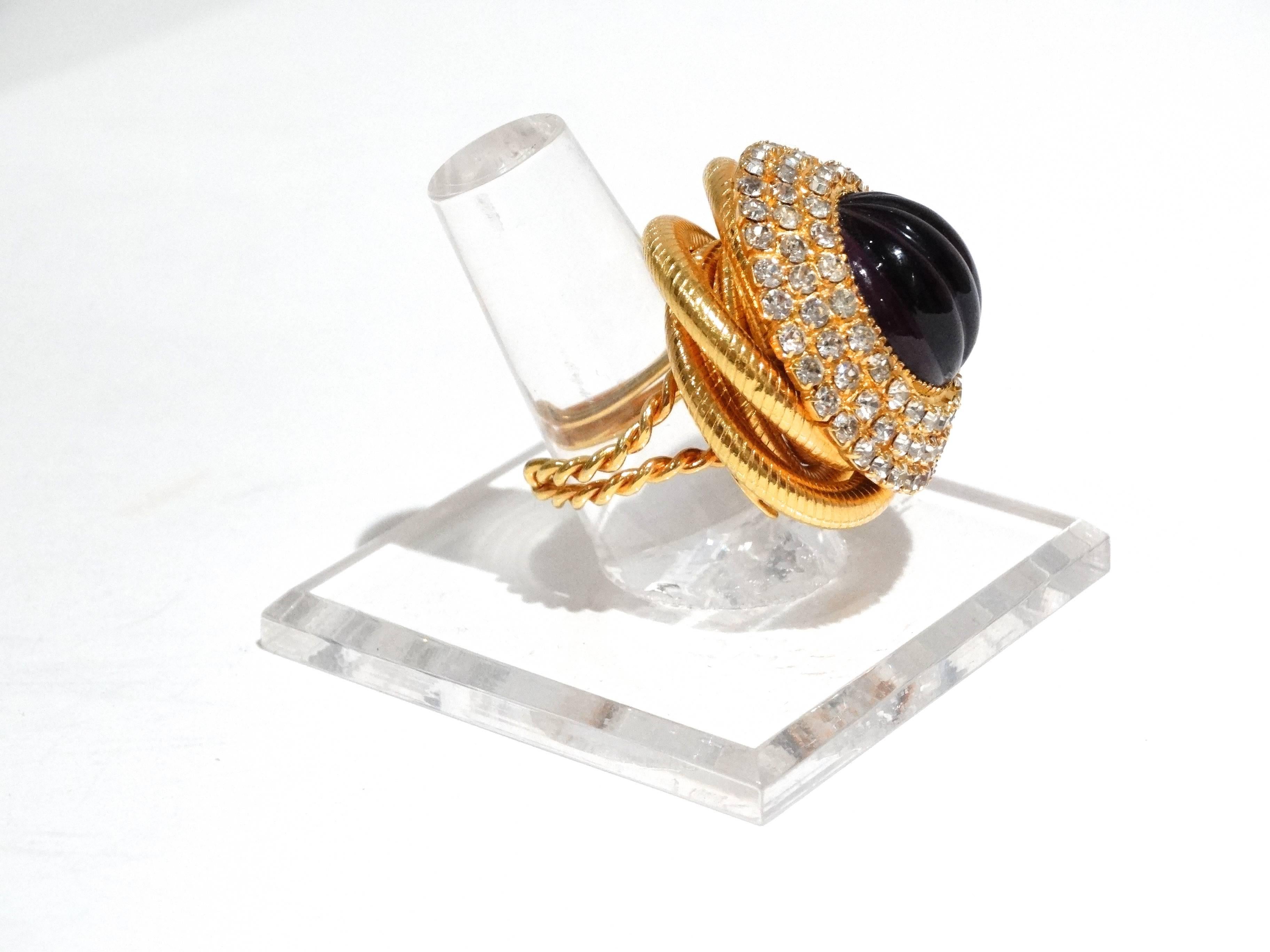 A true red carpet center piece! All hand done, the metal work is intricate and elaborate, with a 3 rows of rhinestones throughout, glass purple cabochon stone is deep and rich in color. The gold plating is very heavy. 
This cocktail ring is signed