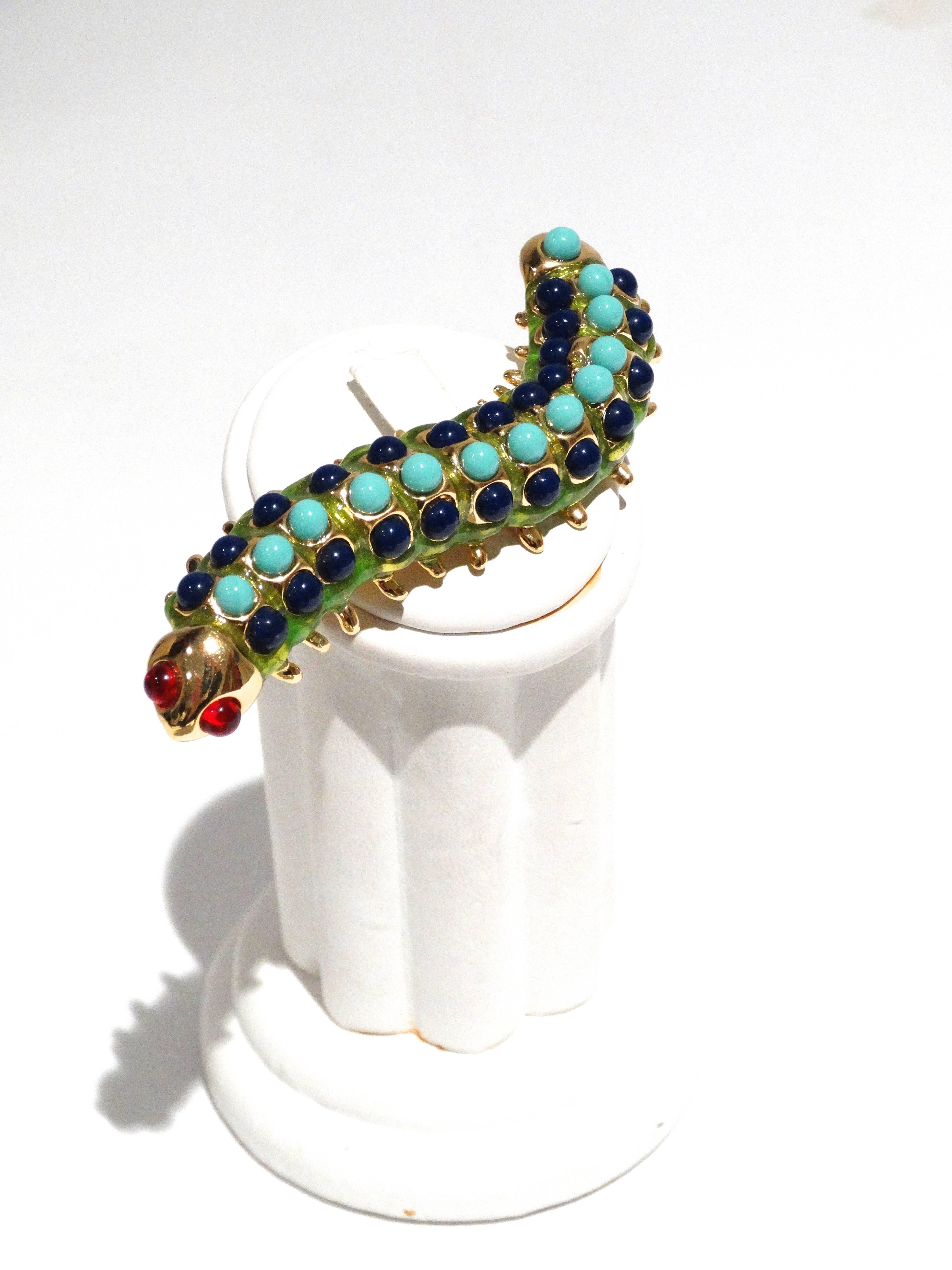 A fun Kenneth Jay Lane Caterpillar brooch circa 1995 in green enamel, glass ruby cabochons, plastic lapis lazuli and turquoise cabochons. Signed KJL. You can also reference this piece in Kenneth Jay Lane's 