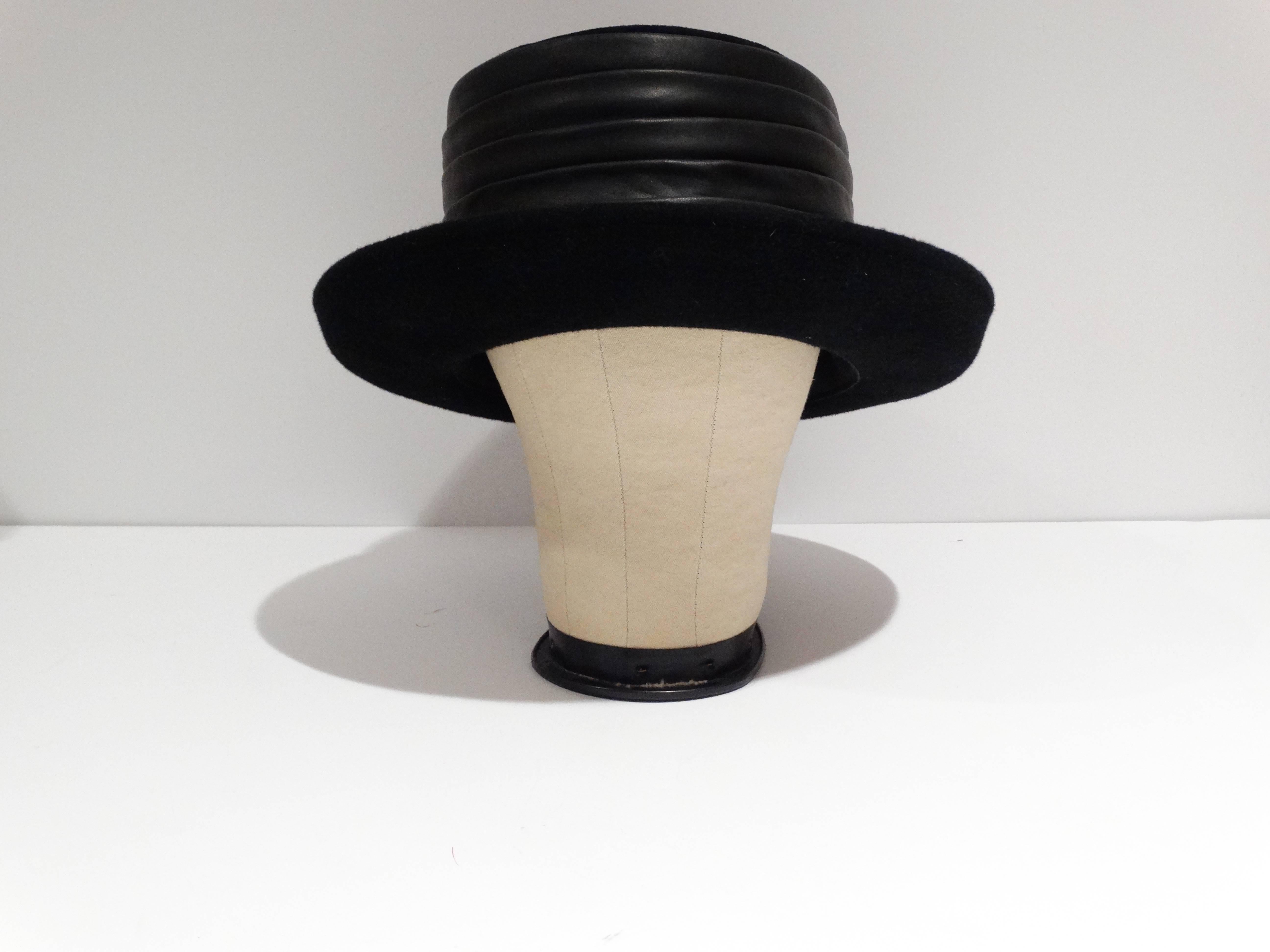 A twist on the top hat, this 1980's Kokin black leather and suede top hat is a show stopper. Unworn with tags still attached purchased from Saks Fifth Avenue. Measures 6 1/2