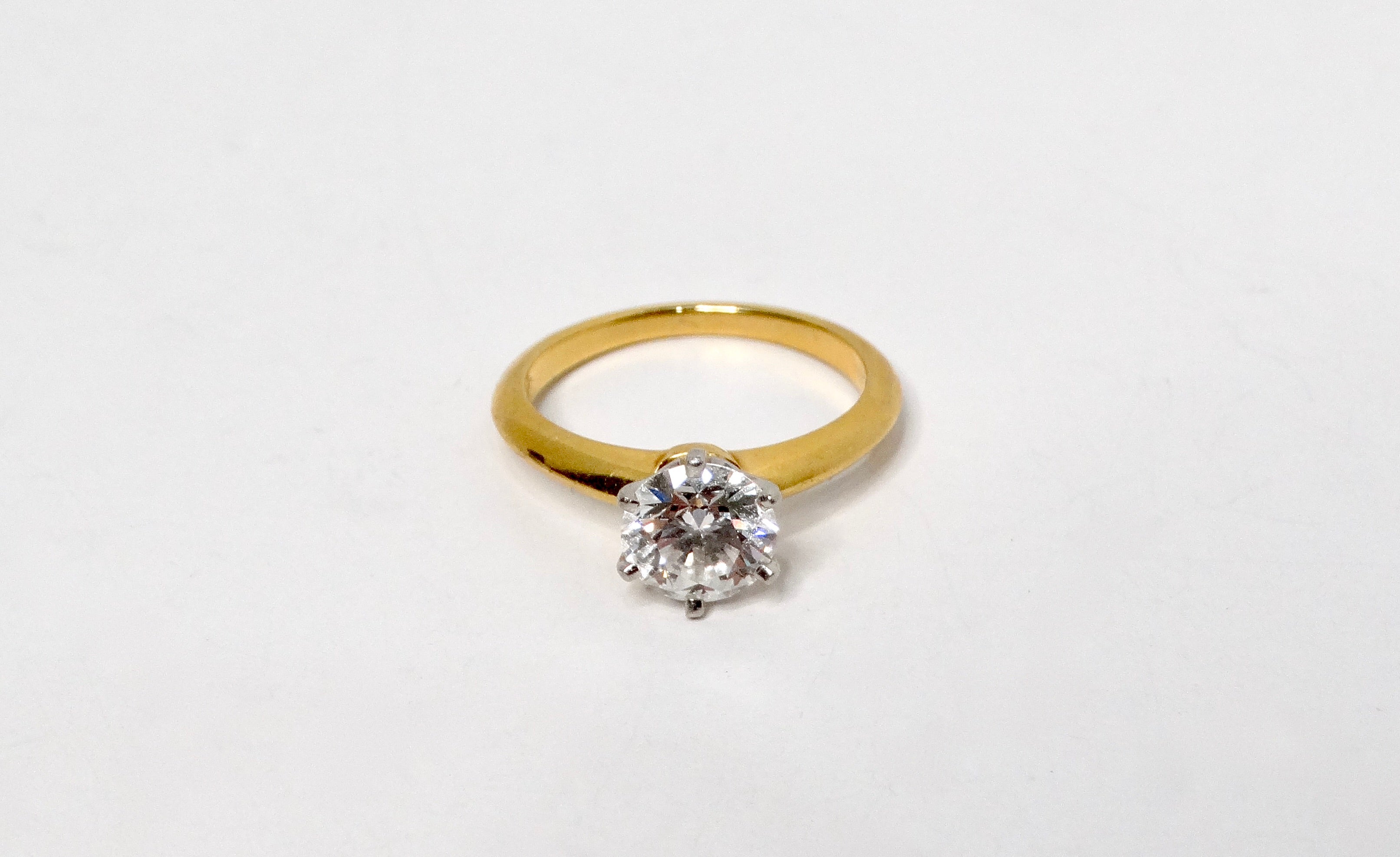 The Tiffany & Co. GIA Certified 1.32 Carat Round Brilliant Diamond Engagement Ring from circa 2000 is a timeless emblem of love and commitment. This exquisite solitaire ring features a dazzling round brilliant cut diamond, boasting an impressive F