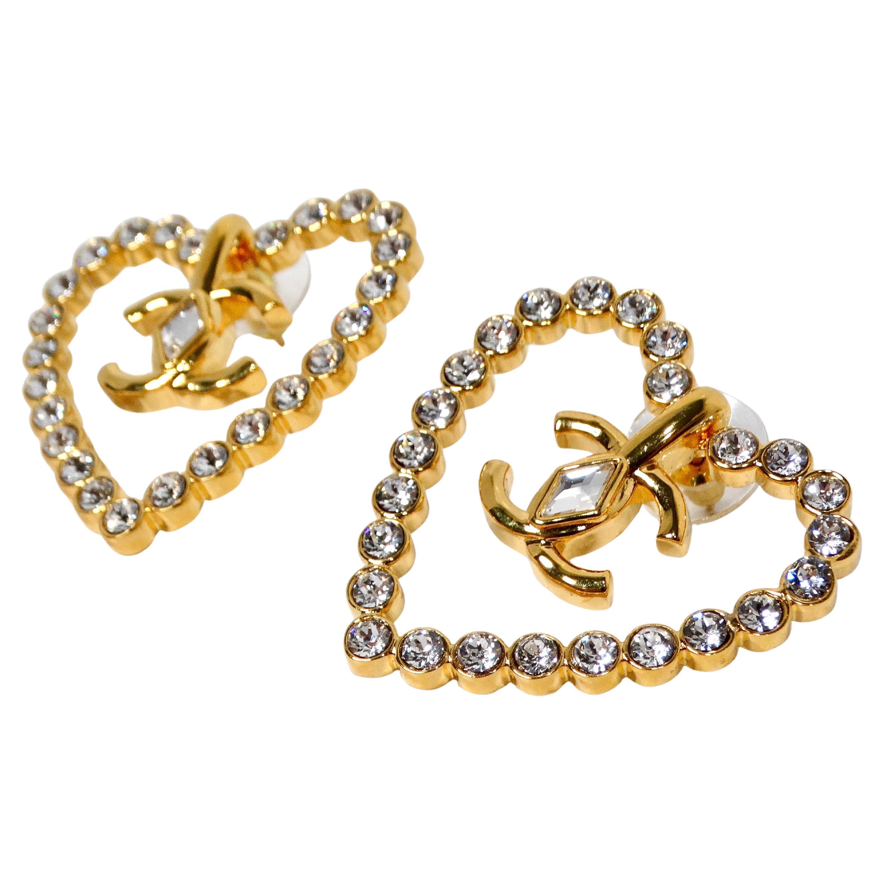 Eleva il tuo gioco di accessori con gli splendidi orecchini Chanel Cruise 2022/23 con cristalli e placcati in oro. Questi orecchini glamour sono realizzati con una deliziosa forma a cuore ornata da cristalli scintillanti che brillano da ogni
