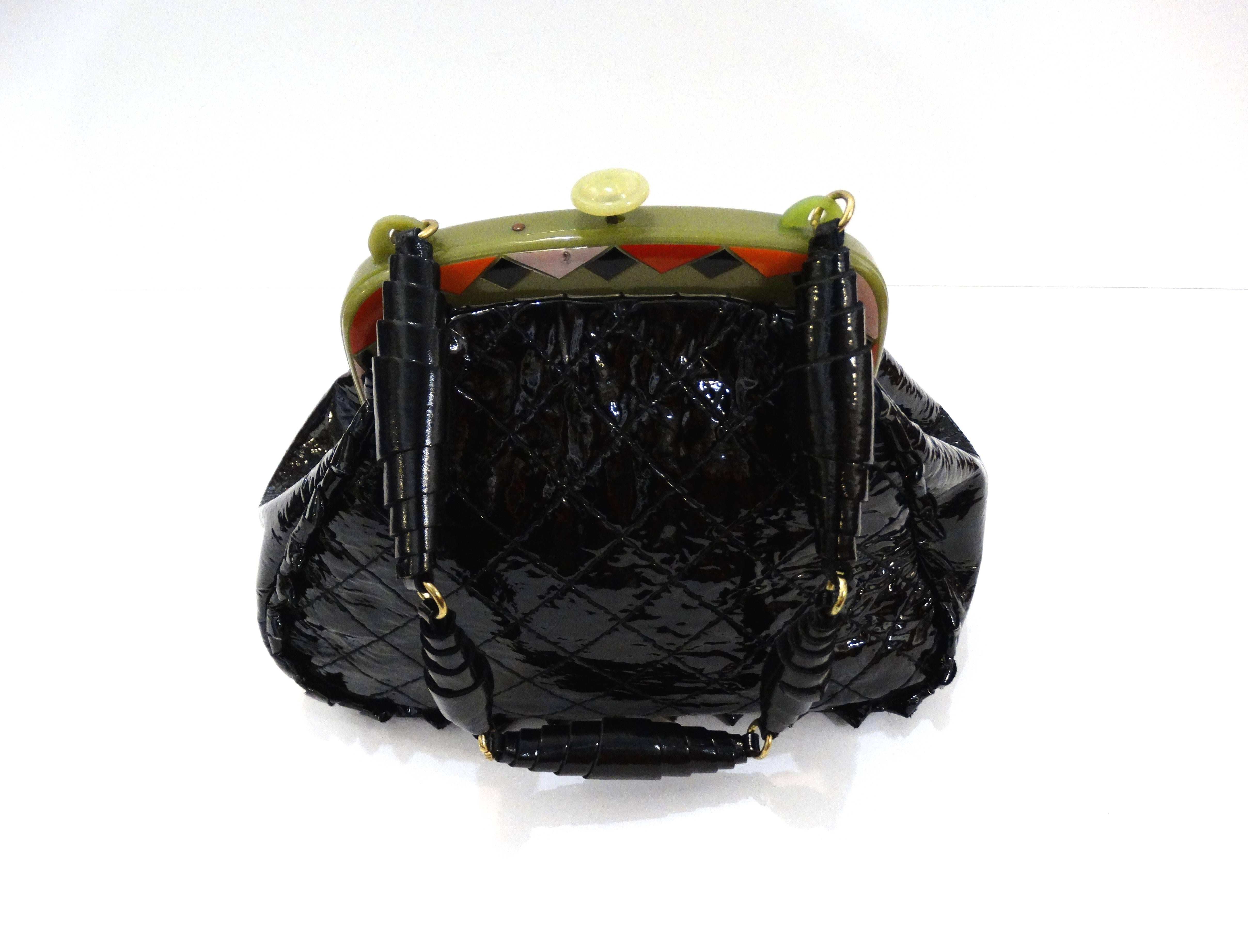 Amazing custom vintage Anthony Luciano black quilted patent handbag, exterior accentuated with a serrated trim. A green plastic top frame featuring colorful red, pastel black geometric shapes, and a unique rolled leather beaded handle. Push to open