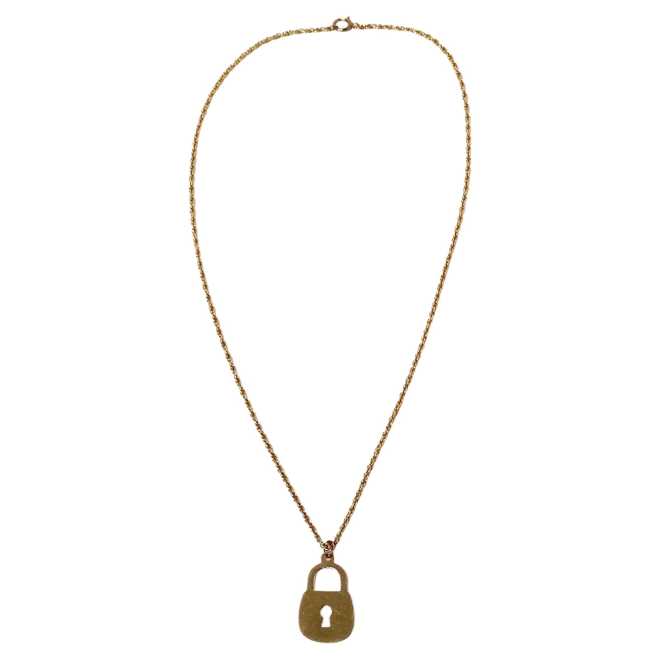 Le collier pendentif cadenas plat à chaîne en or 14k est une pièce remarquable qui allie élégance intemporelle et sophistication moderne. Fabriquée en or 14 carats, la chaîne en corde présente des maillons torsadés complexes qui créent un aspect