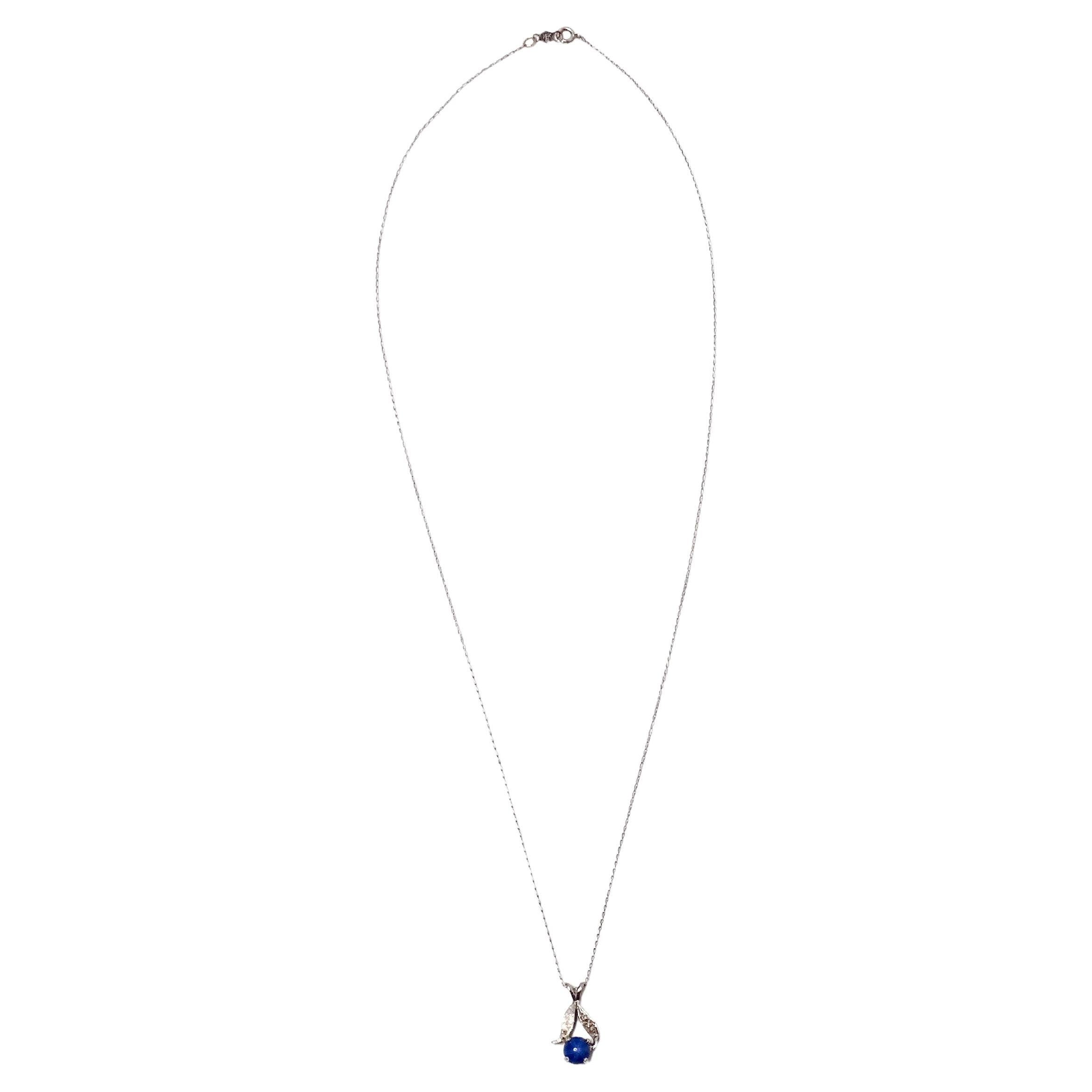 Ce superbe collier pendentif en or blanc 14k Blue Star Sapphire, datant des années 1960, respire l'élégance intemporelle et le savoir-faire artisanal. Le pendentif est orné d'un saphir étoilé captivant, réputé pour son effet d'astérisme unique, qui