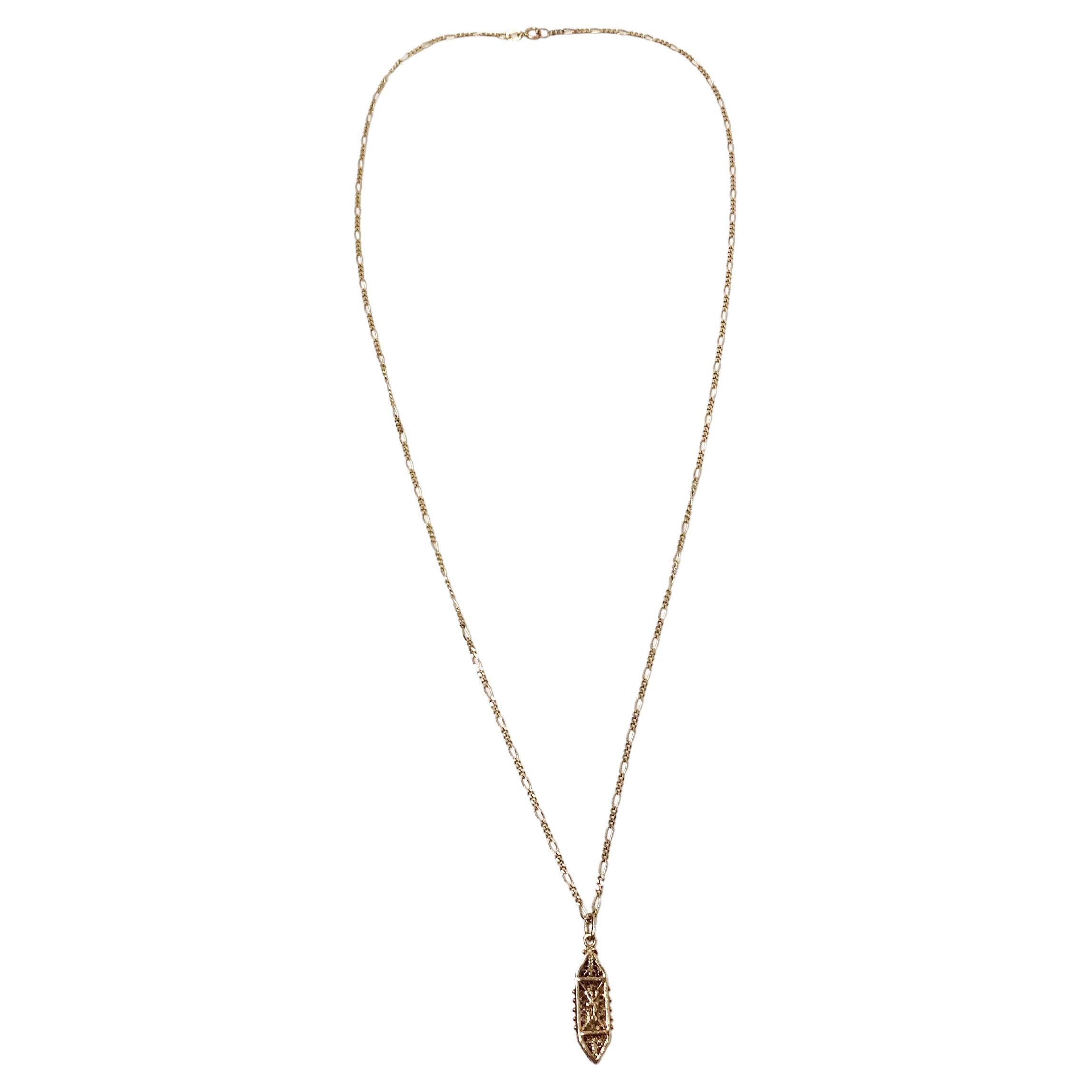 La collana con ciondolo Mezuzah in oro 14k a catena filigranata, risalente agli anni '90 circa, è uno splendido esempio di alta gioielleria artigianale e di significato culturale. Realizzato in oro 14 carati di alta qualità, questo pezzo presenta un