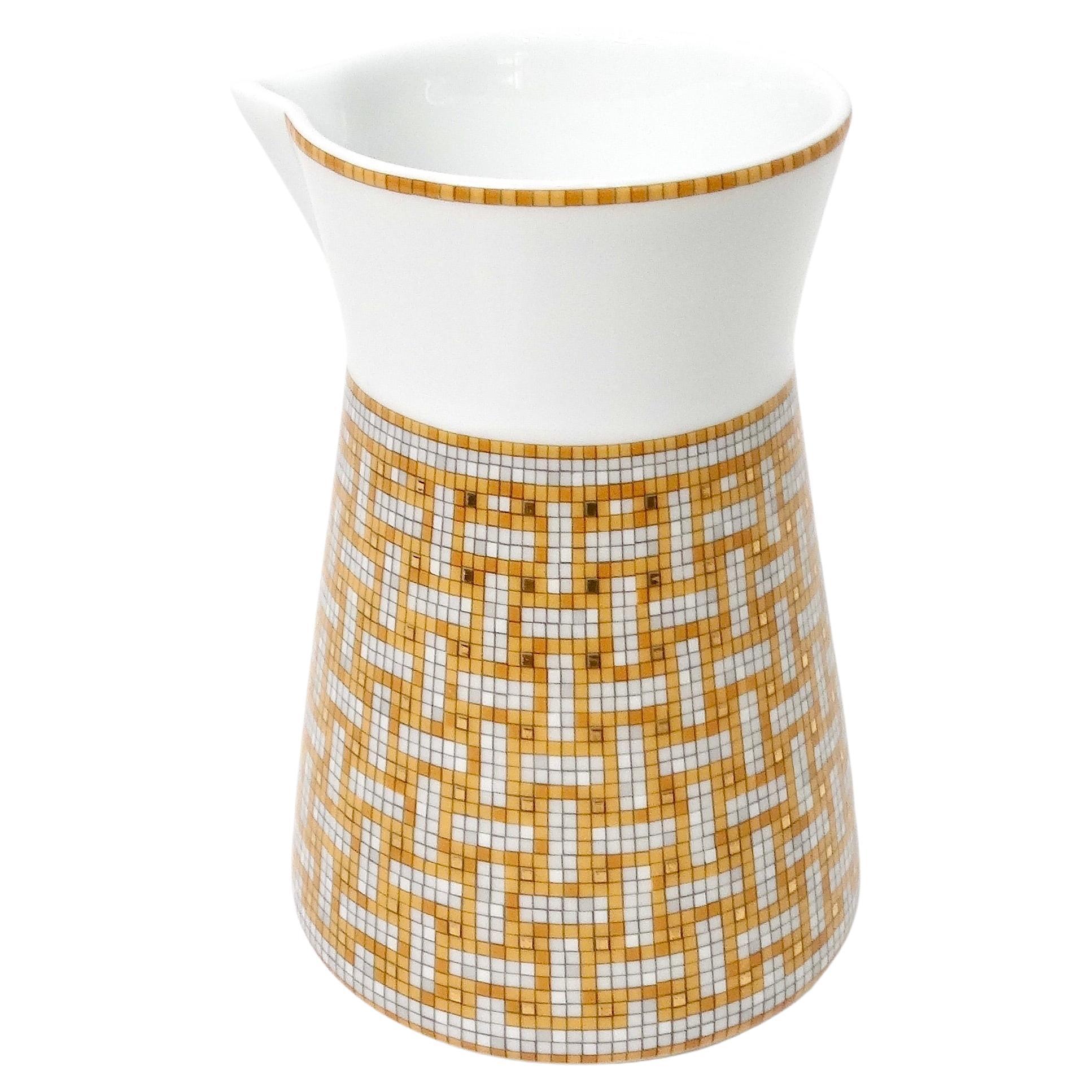 Le pot à lait en porcelaine Hermes Mosaique au 24 Van Quatre Gold est un exemple frappant d'artisanat luxueux et de design artistique. Avec son imprimé mosaïque vibrant dans les tons jaune, orange, blanc et or, cette pièce incarne l'élégance de