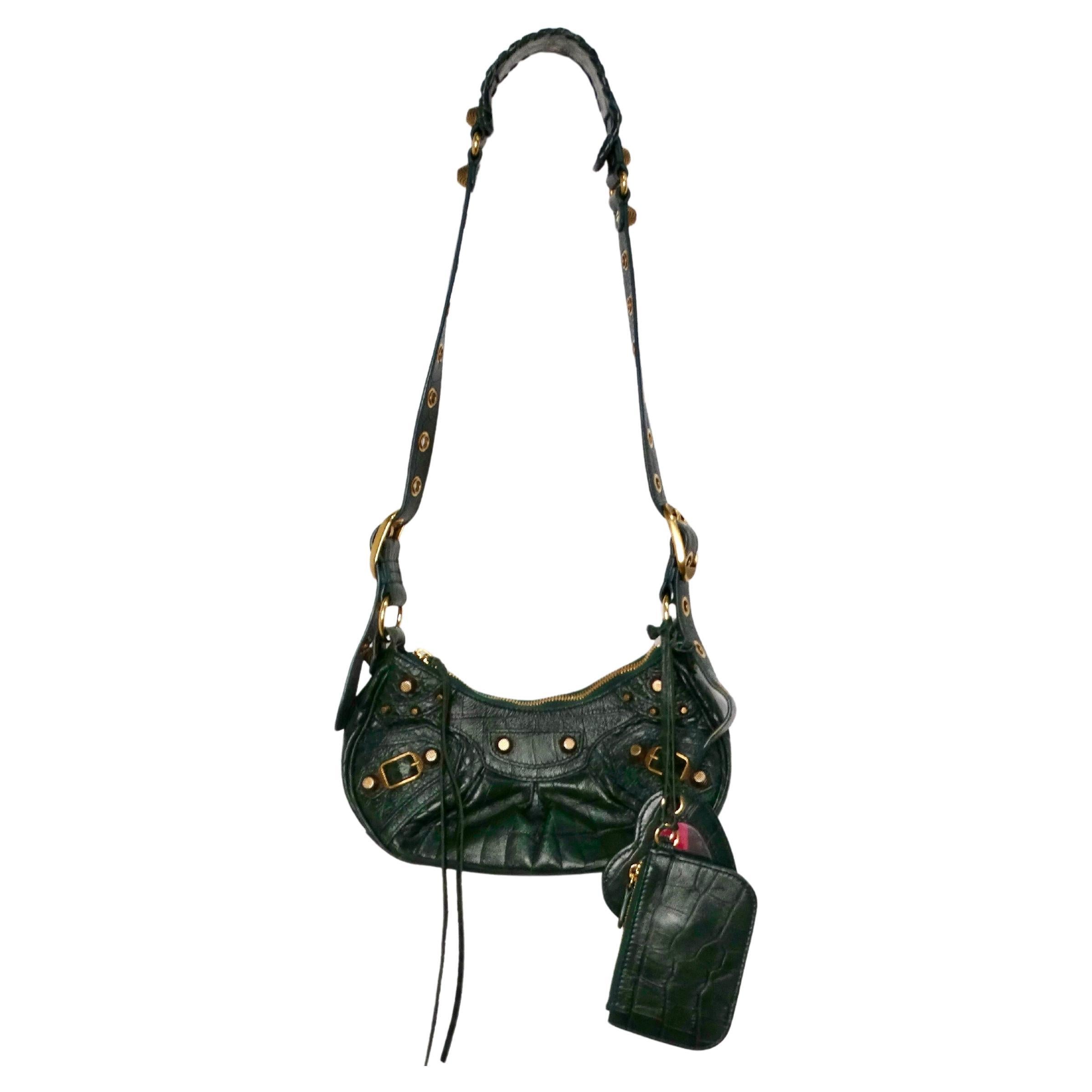 Die Balenciaga Le Cagole Green Leather Croc Embossed XS Shoulder Bag von circa 2022 ist ein auffälliges Accessoire, das kühnes Design mit luxuriöser Handwerkskunst verbindet. Diese Tasche aus dunkelgrünem Leder mit auffälliger Kroko-Prägung strahlt