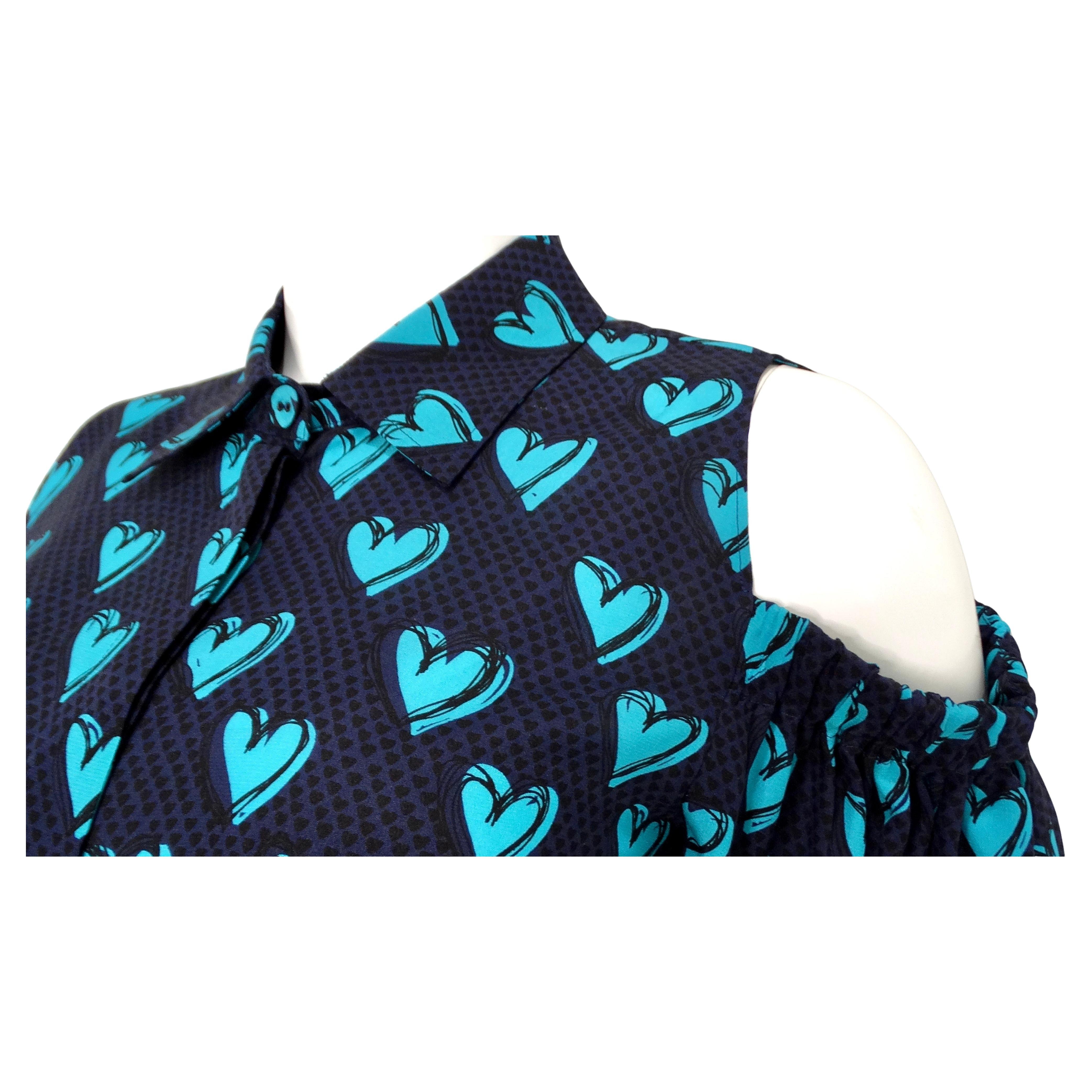 Le chemisier à manches longues boutonnées en soie imprimée cœur bleu de Fendi est une pièce saisissante et sophistiquée qui allie sans effort charme ludique et élégance haut de gamme. Confectionnée en soie luxueuse, cette blouse présente une base
