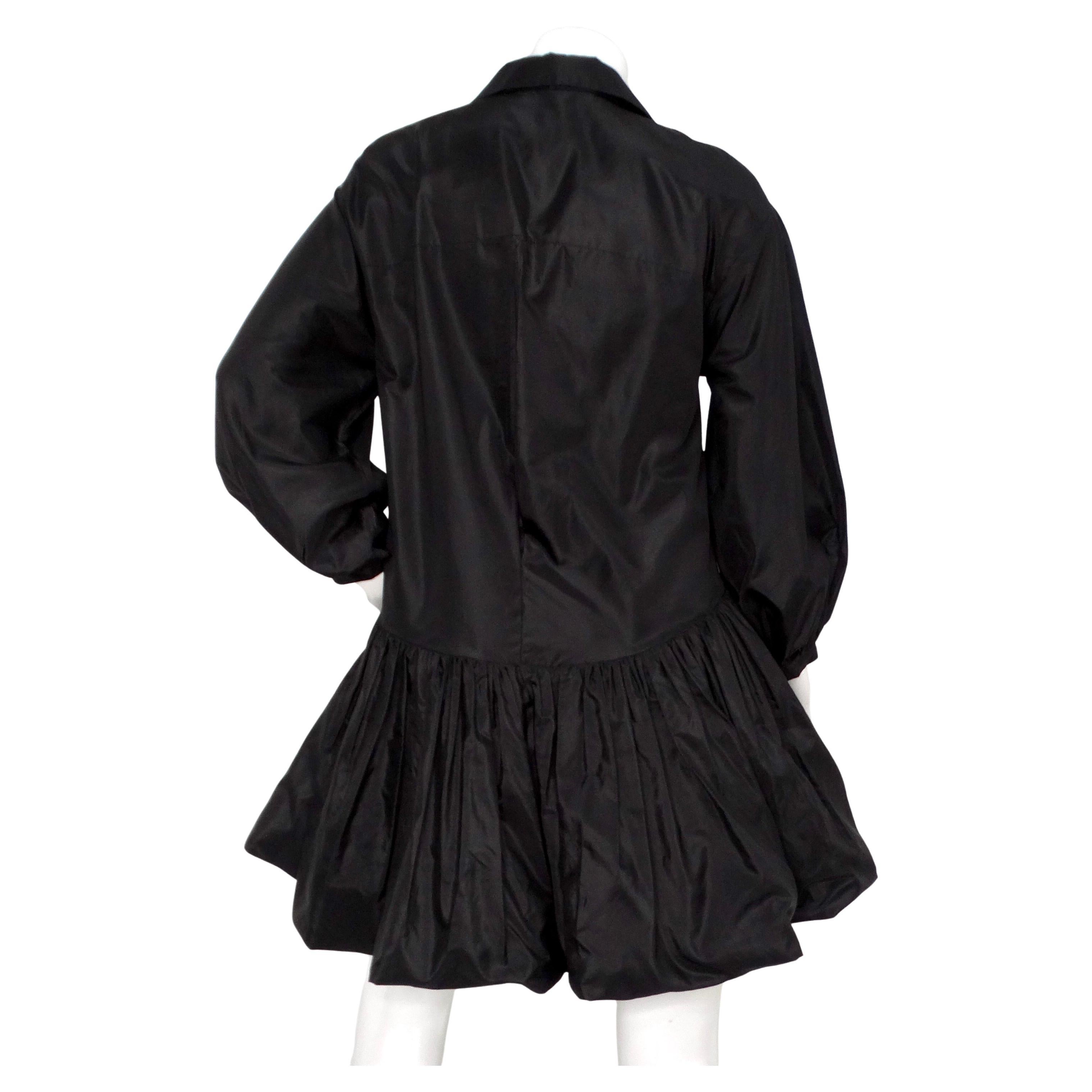 Il Valentino Black Silk Taffeta Button-Up Long-Sleeve Shirt Dress emana un'eleganza sofisticata e dettagli di design meticolosi. Realizzato in taffetà di seta di alta qualità, questo abito offre una finitura elegante e lucente che eleva qualsiasi