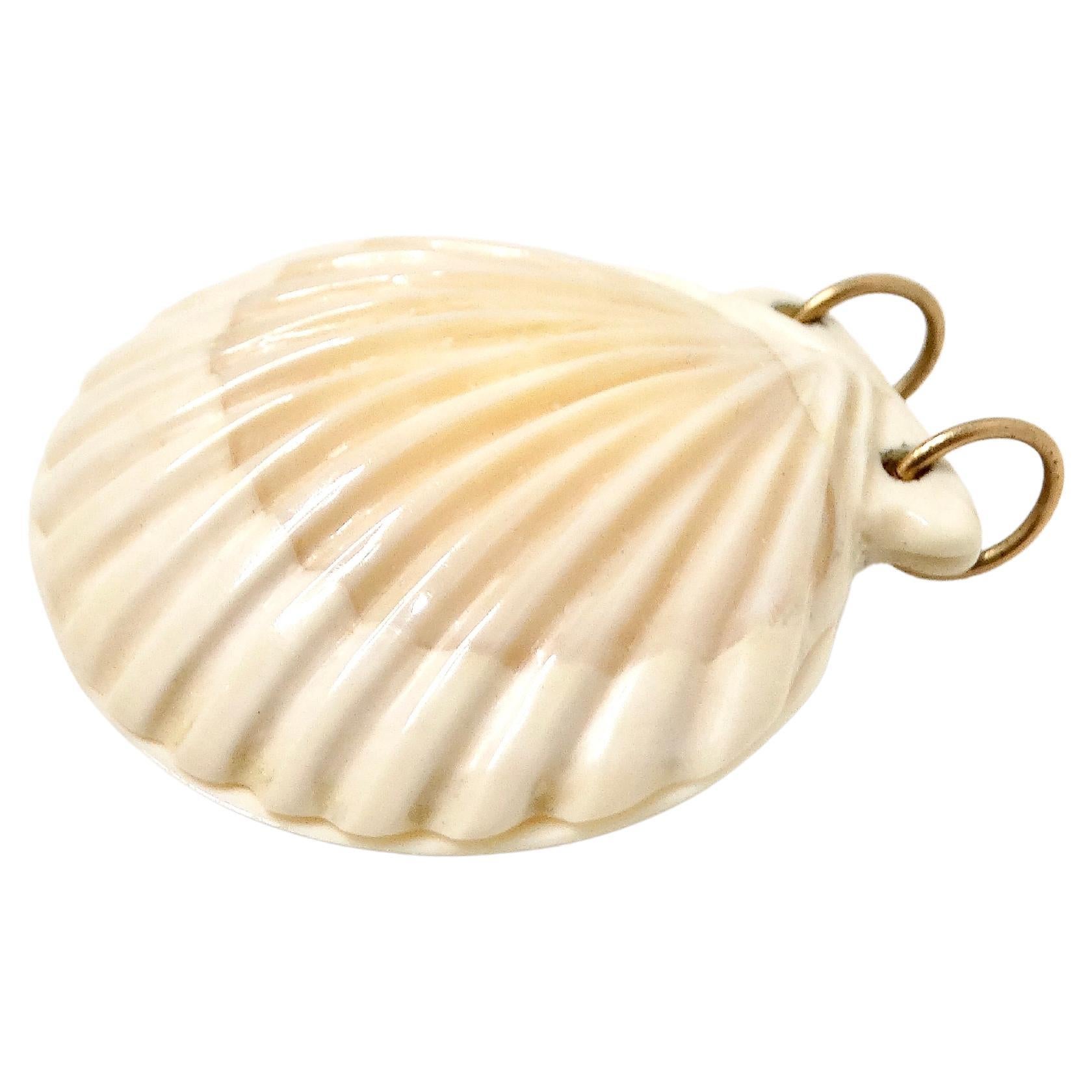 Questo incantevole ciondolo a forma di conchiglia smerlata in oro 14k, risalente agli anni '70 circa, emana un'affascinante allure vintage. Realizzato in caldo e lucente oro 14k, il ciondolo presenta un design a conchiglia smerlata delicatamente