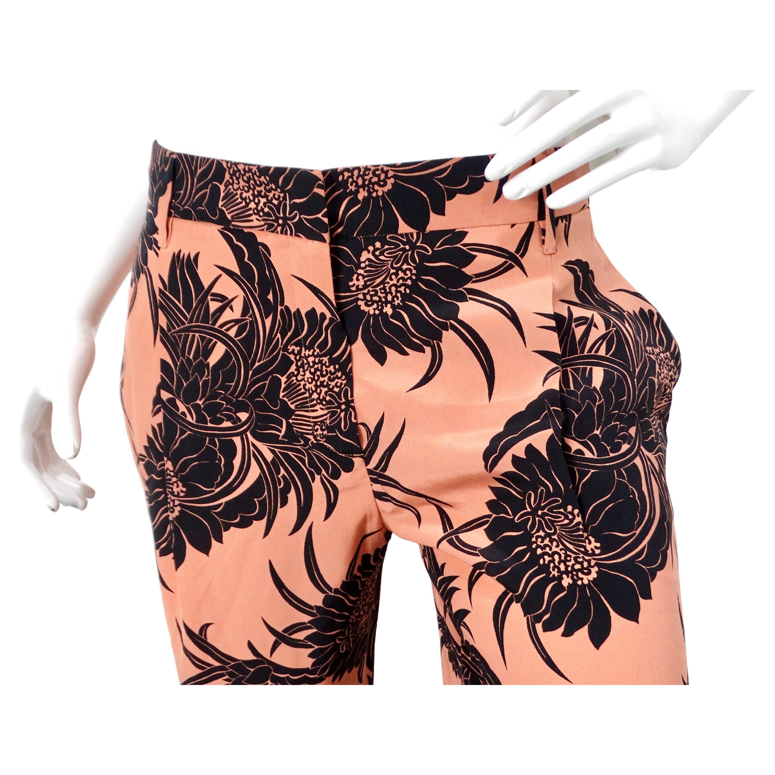 Le pantalon court en soie imprimé hibiscus rose de Prada, datant de circa 2014, incarne un mélange saisissant d'élégance et d'allure tropicale. Le pantalon présente une base rose terracotta chaude qui dégage un charme subtil et vibrant à la fois,