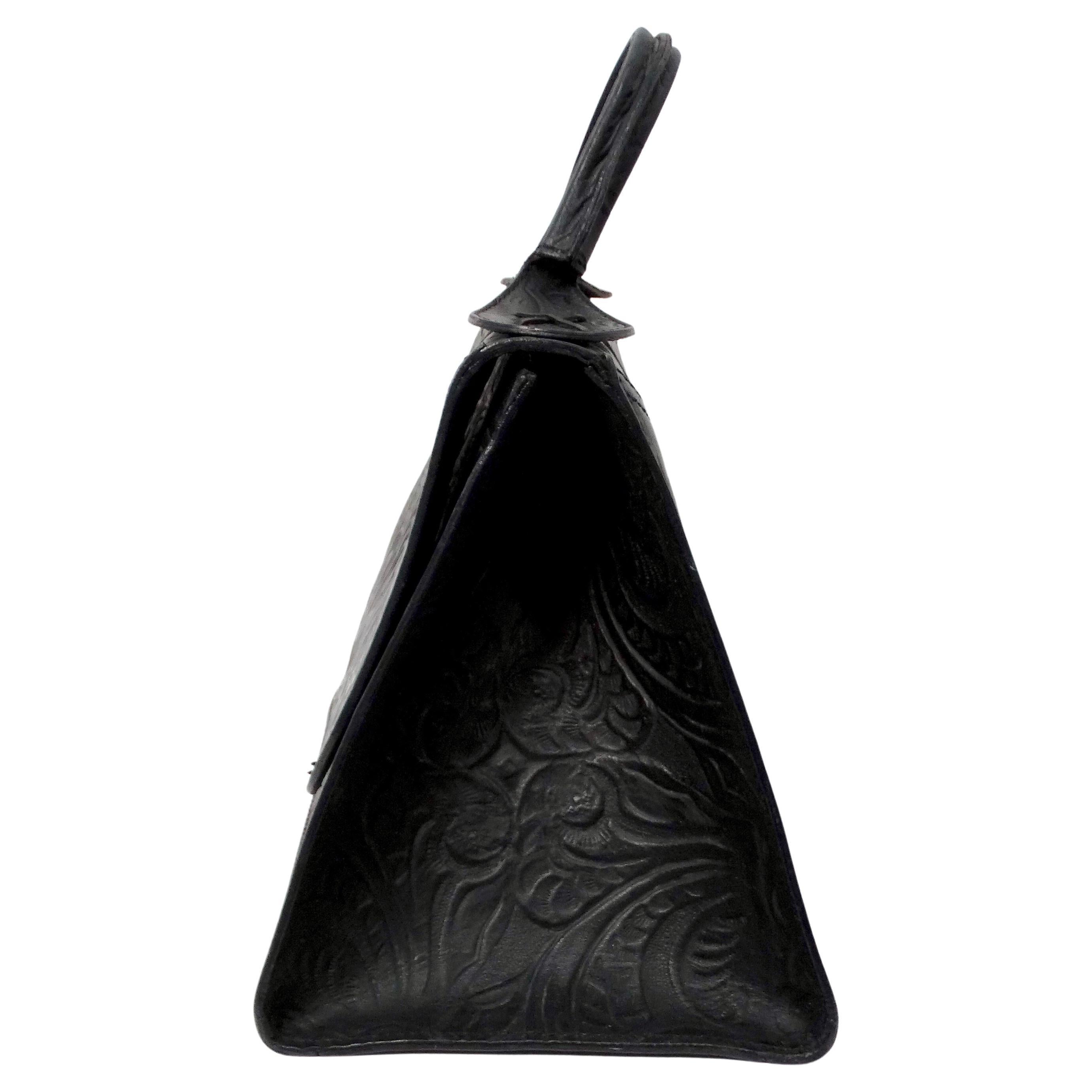 El bolso de solapa de piel negra con estampado floral de Fendi de los años setenta es un impresionante ejemplo de artesanía italiana vintage y elegancia atemporal. Fabricado en lujosa piel negra, este bolso presenta un intrincado relieve floral que