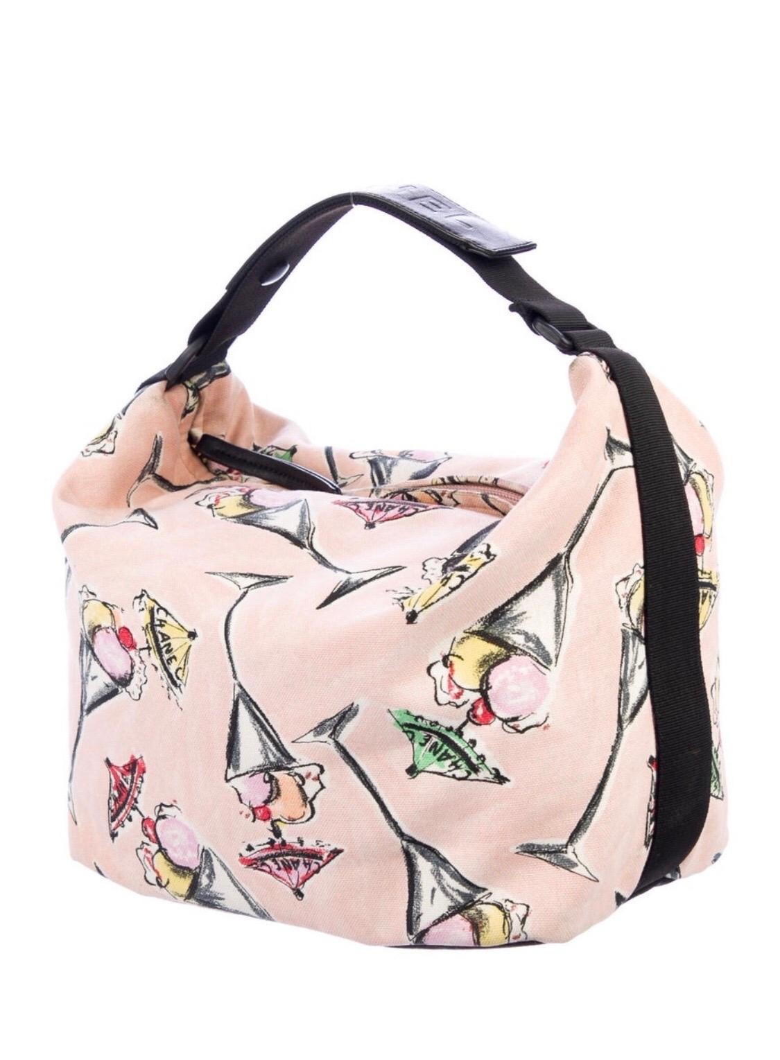 ¡Adorable bolso Chanel perfecto para todos tus días de paseo! Circa 2003-2004, esta asa superior de lona presenta un motivo de helado con paraguas Chanel. Asa superior estilo hebilla estampada Chanel con dos cierres de botón a presión. El interior