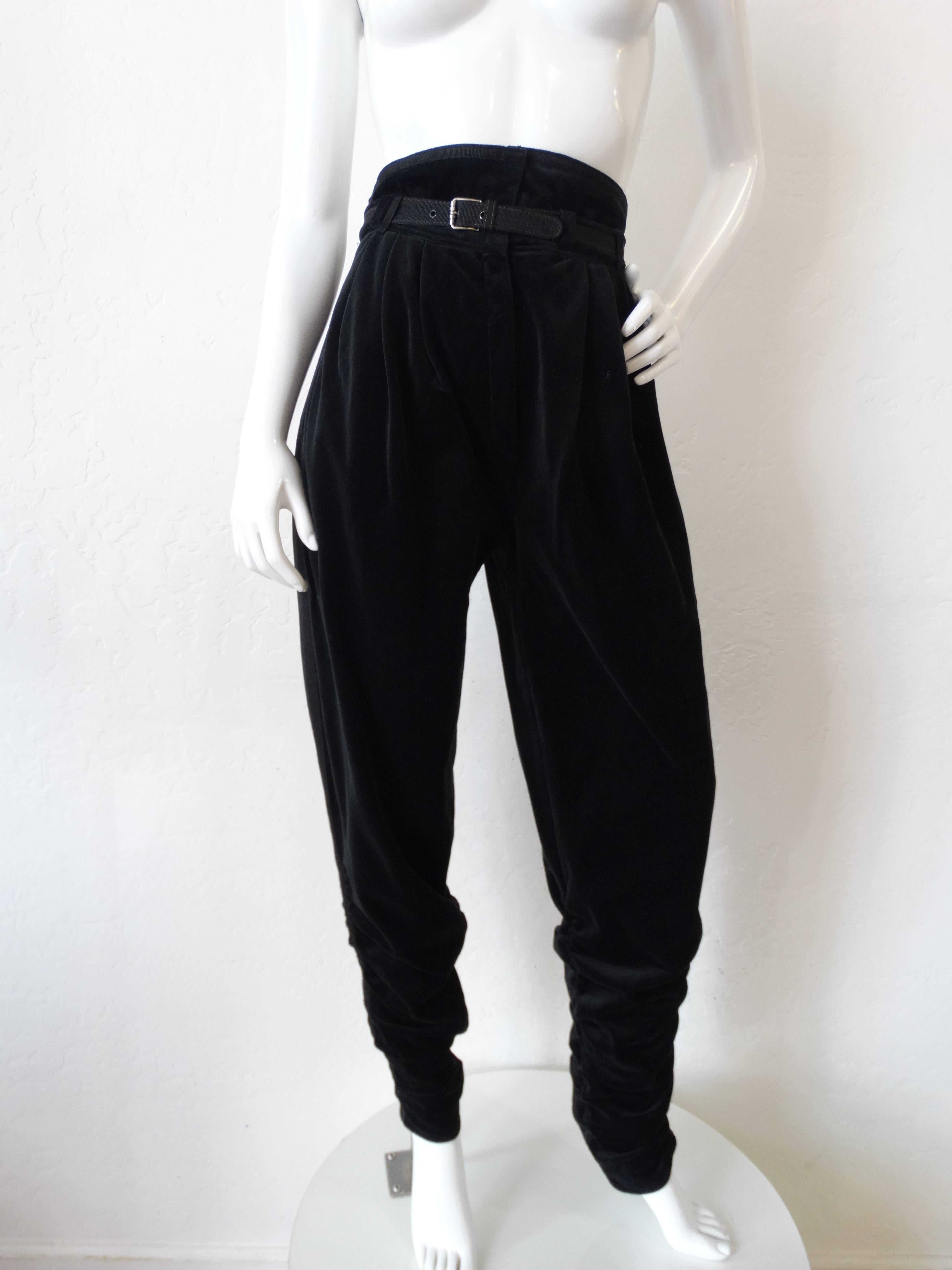 Up your fall wardrobe game in our 1980s Gianni Versace pants! Made of a luxurious midnight black velvet with grosgrain trim accents and matching belt. Super high waisted rise with flattering tapered legs. Velvet gathered around the ankles and legs,