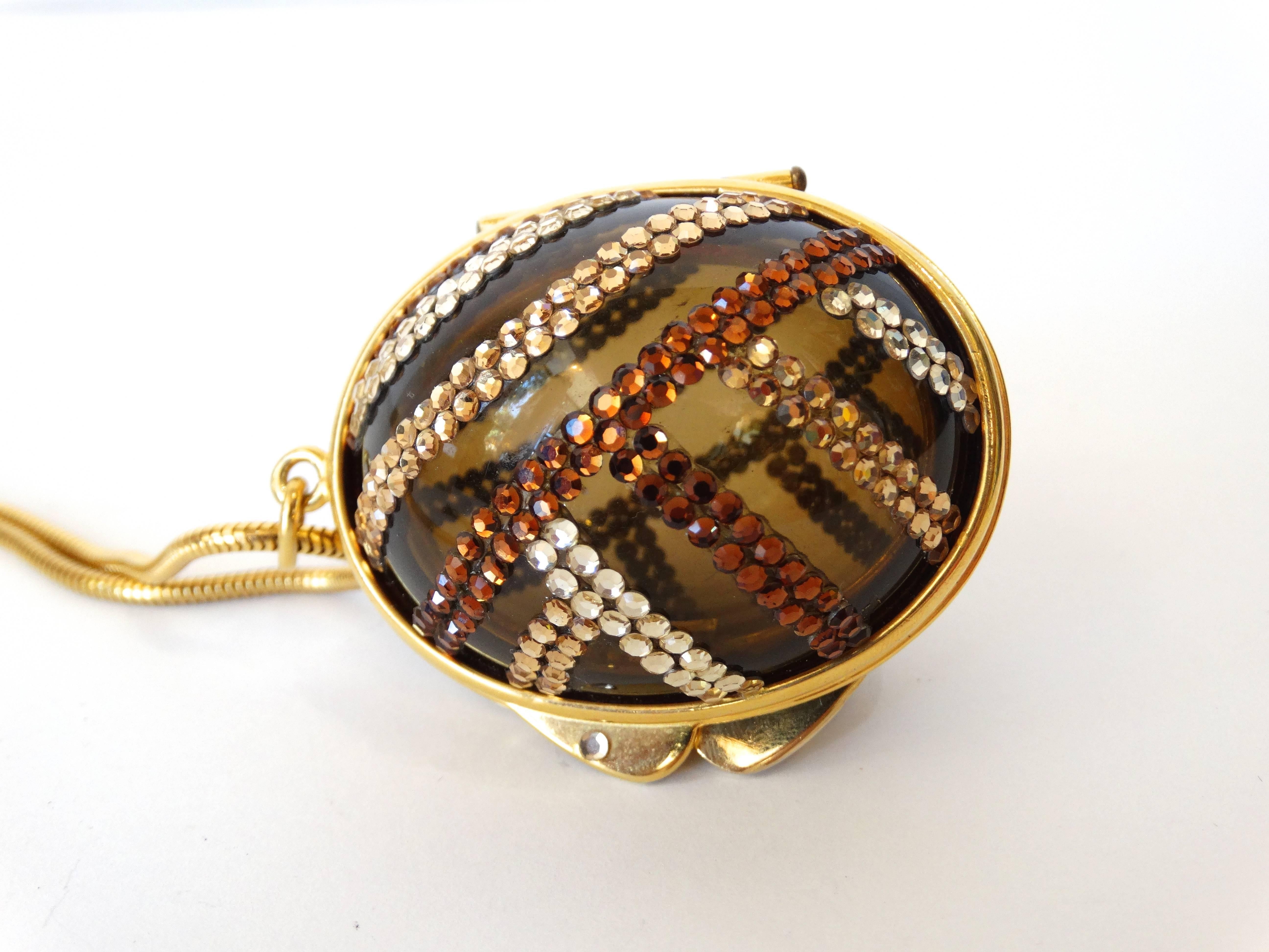 The incredible 1980s Judith Leiber egg locket! This piece is hard to come by- by the prolific jewelry and handbag designer Judith Leiber! Super unique egg shaped locket made of a clear brown lucite and accented with tan and brown crystals. Gold