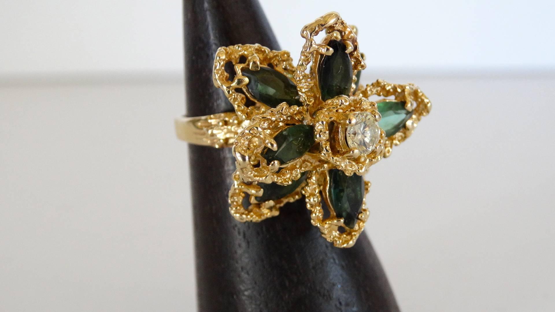 This beautiful flower ring is made with 18 karat gold, 3 carat total weight of green tourmaline and .40 carat diamond center stone. Total weight in grams is 10.85. This ring is a size 6, of course can be sized. Such a unique design. If you have any