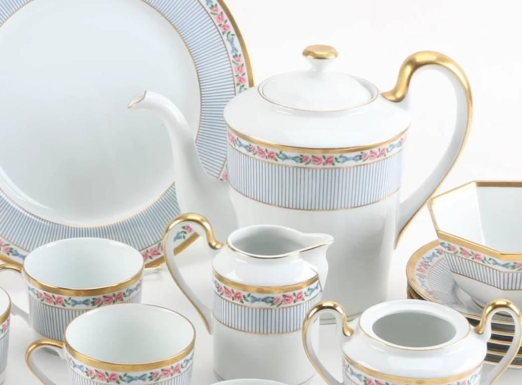 A collection of Christian Dior Dior Rose tea set, circa 1991-1999. This fifteen piece collection of porcelain tableware from Christian Dior is presented in the Dior Rose pattern with a floral rose band with gray vertical lines, gold rim. Dior logo