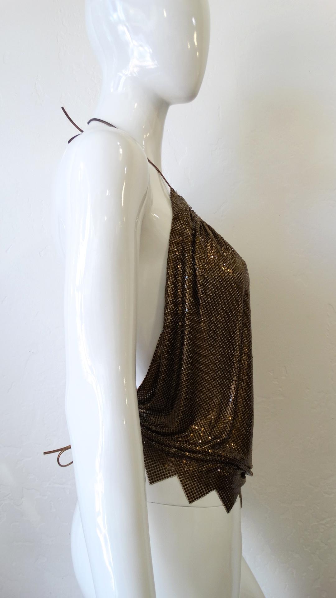 Bring The 70s Back With This Metal Mesh Backless Halter Top! By Whiting and Davis, this top features a gorgeous bronze color. Includes metallic bronze ties to the halter neck and to the back at the waist, with a ruched circular neckline and a