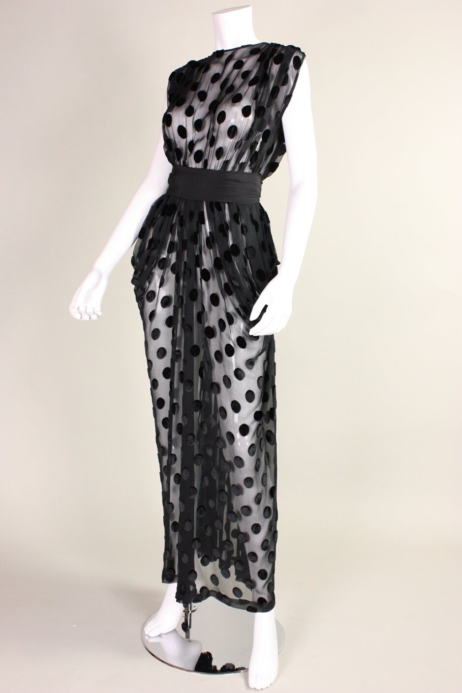 Vintage gown from Givenchy is made of black dotted chiffon and dates to the late 1970's through the early 1980's.  Draping at hips creates a dramatic focal point.  Center back keyhole opening.  Detached waist sash.  Center back hook and eye and snap