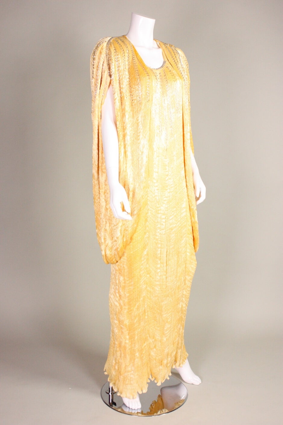 Vintage dress and coat ensemble from Patricia Lester is made of buttery yellow pleated silk with silver bugle bead adornment.  Sleeveless dress has scoop front and back neck.  Cocoon coat has large shoulder pads and no closures.  Both pieces are