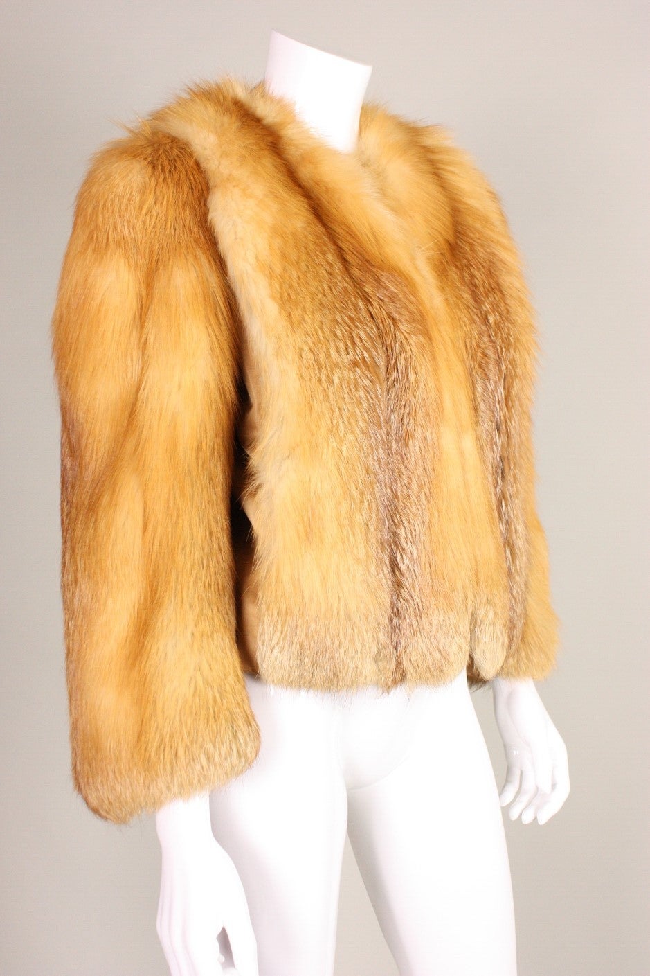Vintage fur jacket dates to the 1970's through 1980's and is made of caramel-colored fox fur.  Turn down collar.  Long sleeves can be made more or less flared at the cuff with covered snap closure.  Center front double hook closure.  Fully lined. 
