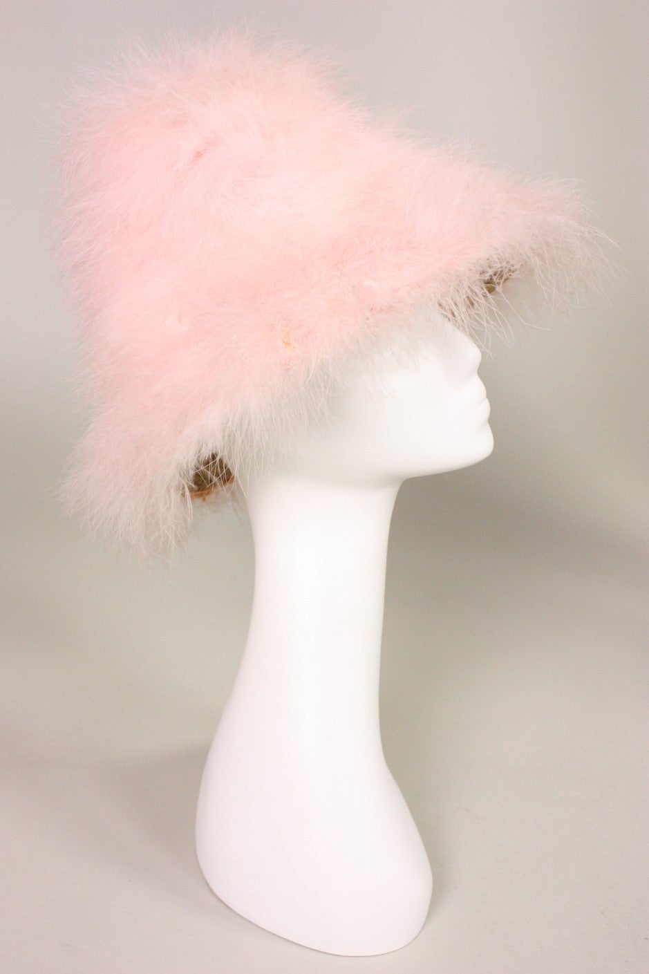 Whimsical hat from Happy Cappers dates to the 1960's and is made of gold straw that is covered with pink marabou feathers.  High crown.  Short brim.  Unlined.

Measurements-

Interior Circumference: 21 5/8