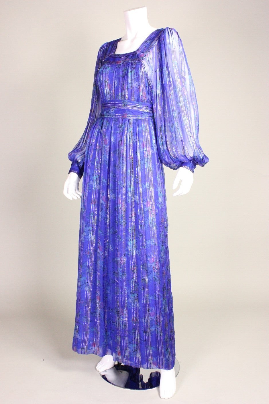 Vintage maxi dress from Raksha dates to the 1970's and is made of printed blue/purple silk chiffon with gold stripes.  Long sleeves button at the cuffs. Lined except for in sleeves. Center back zipper.

Labeled size Medium.

Measurements-
Bust:
