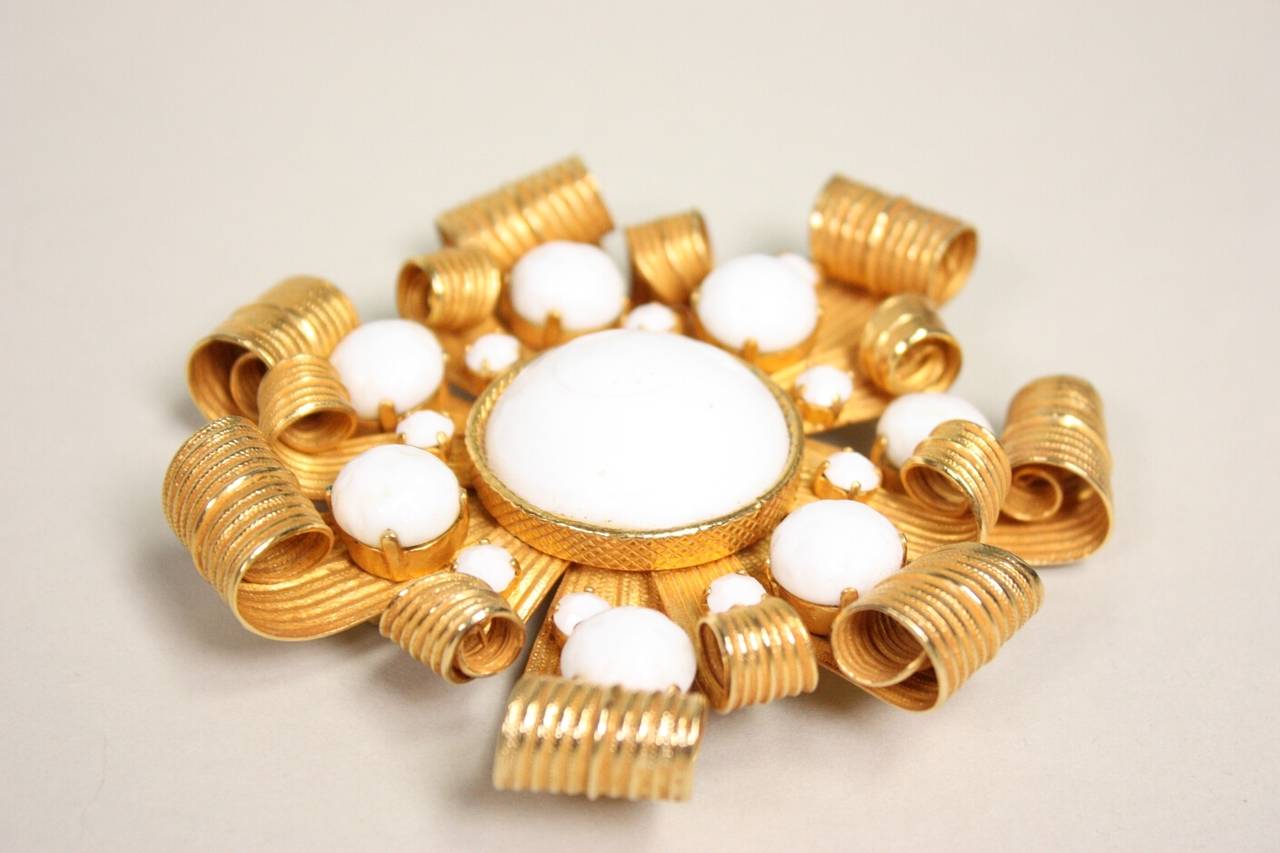 Dominique Aurientis brooch is made of gold-toned metal with textured white glass beads.  It measures 3 1/2