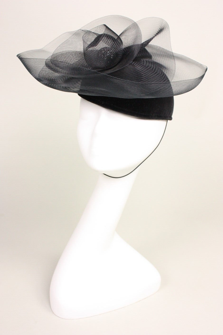 Fun cocktail hat from the late famed English milliner Philip Somerville is made of black felt with stiff black netting arranged concentrically.  Lined.  

Measures 21 1/4