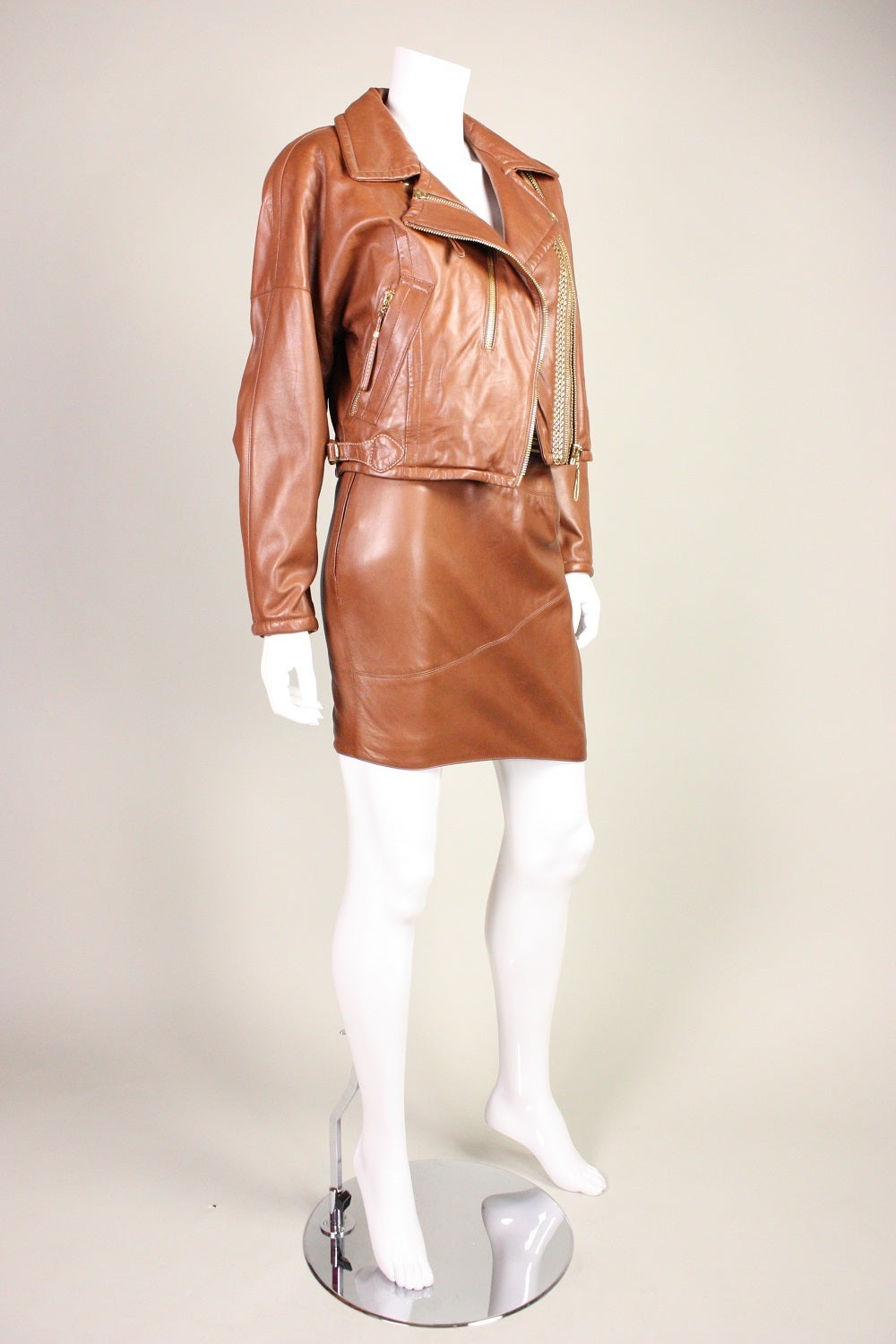 Fabulous suit from Gianfranco Ferre is made of buttery soft brown leather and features gold-toned hardware.  Both pieces are lined and have zippered closures.

No size label, but we estimate it would fit a size