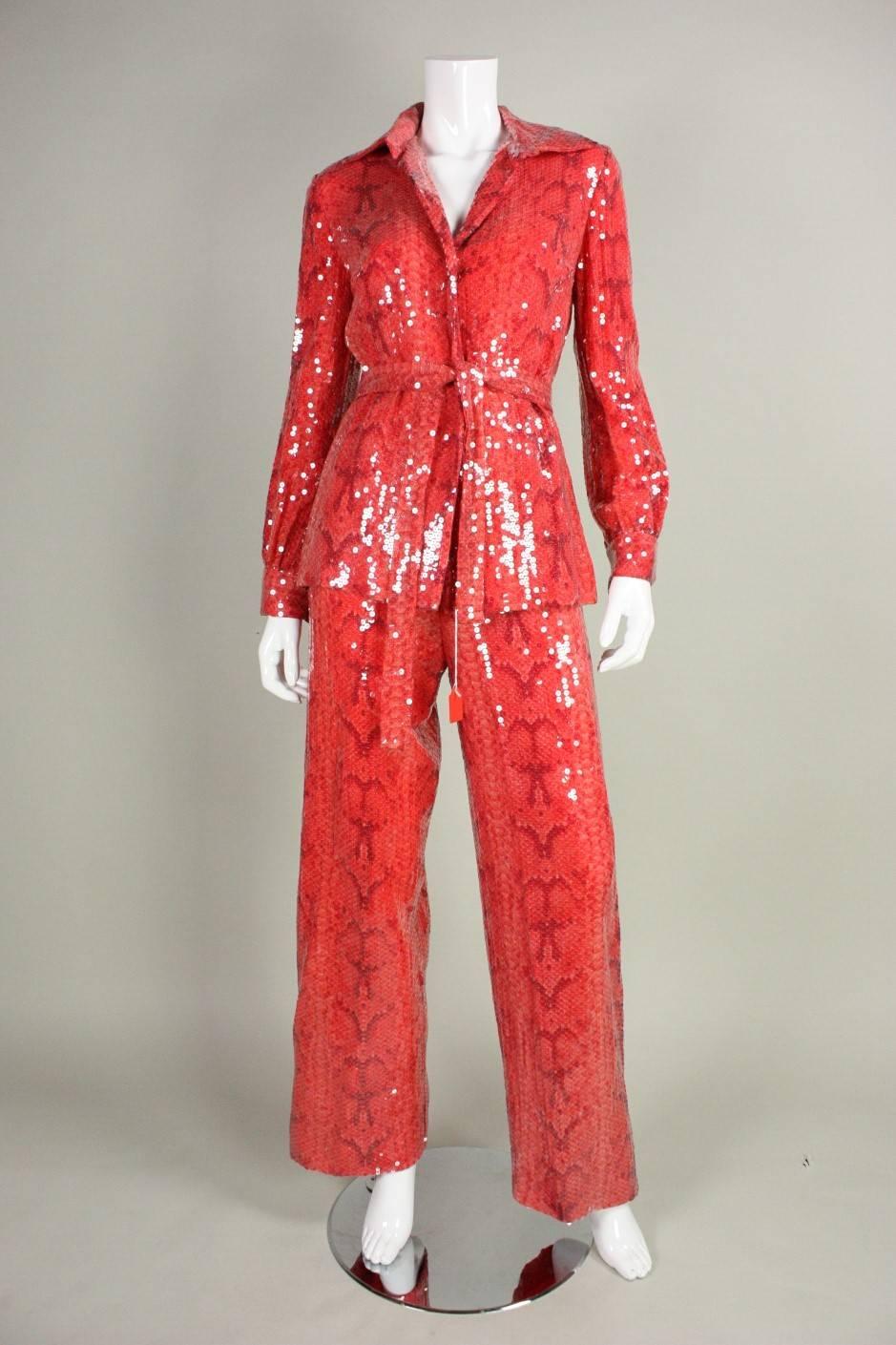 Glamorous ensemble from Bill Blass is made of red silk with a snakeskin print.  Ensemble is entirely covered with clear sequins. Blouse has hidden snap closure down the center front, turn-down collar, and long sleeves with snap cuffs.