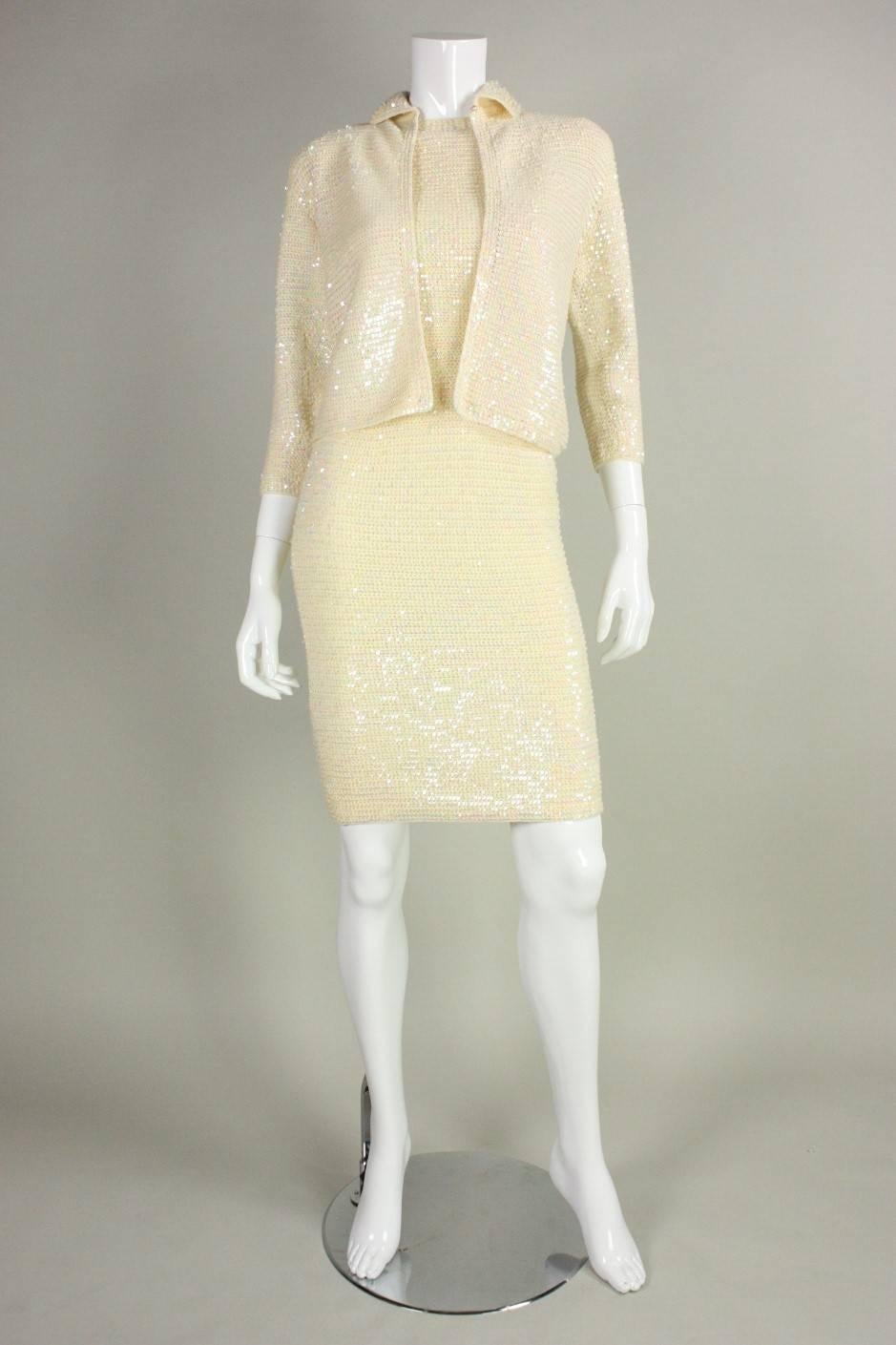 Vintage dress and sweater ensemble was made by Italian designer Anna Giovannozzi and features a cream knit ground that is completely covered with iridescent sequins.  Sleeveless dress has round neck and is fitted throughout.  Waist-length sweater